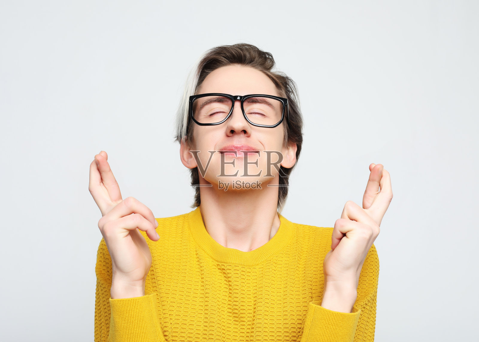 迷人的白人男子举起双手，手指交叉，微笑的肖像照片摄影图片