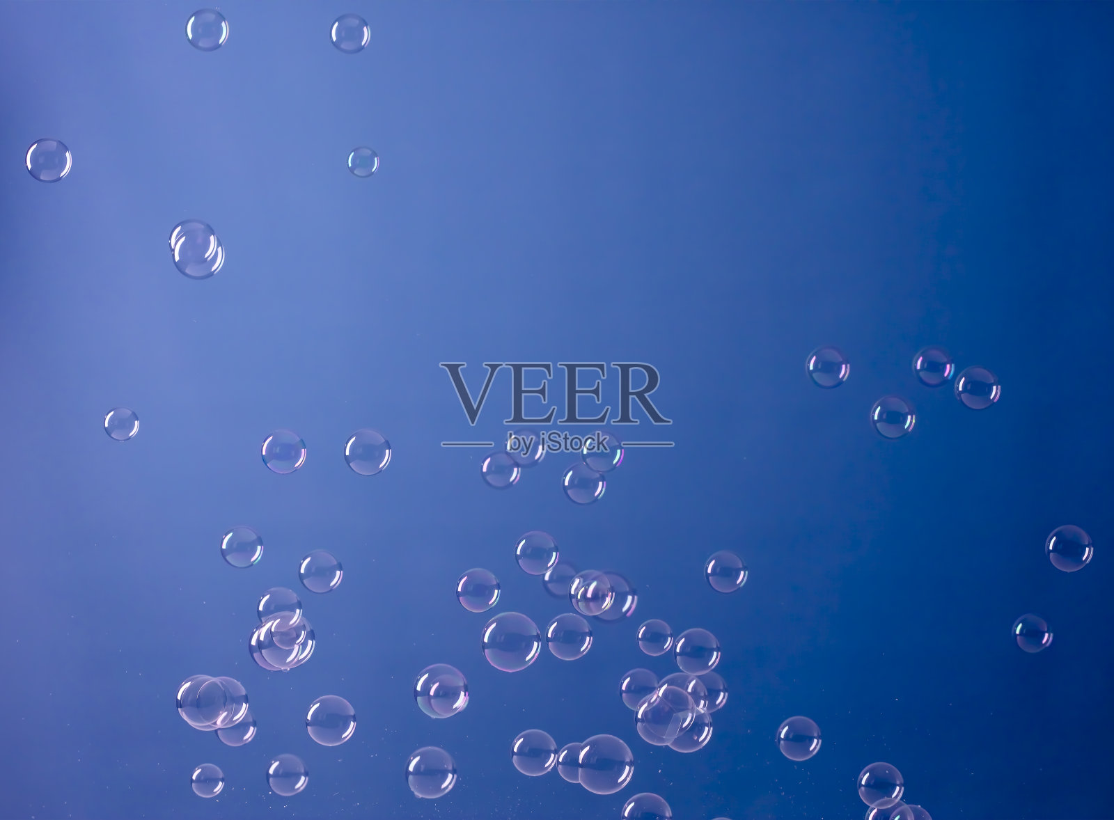 蓝色背景上的肥皂泡照片摄影图片