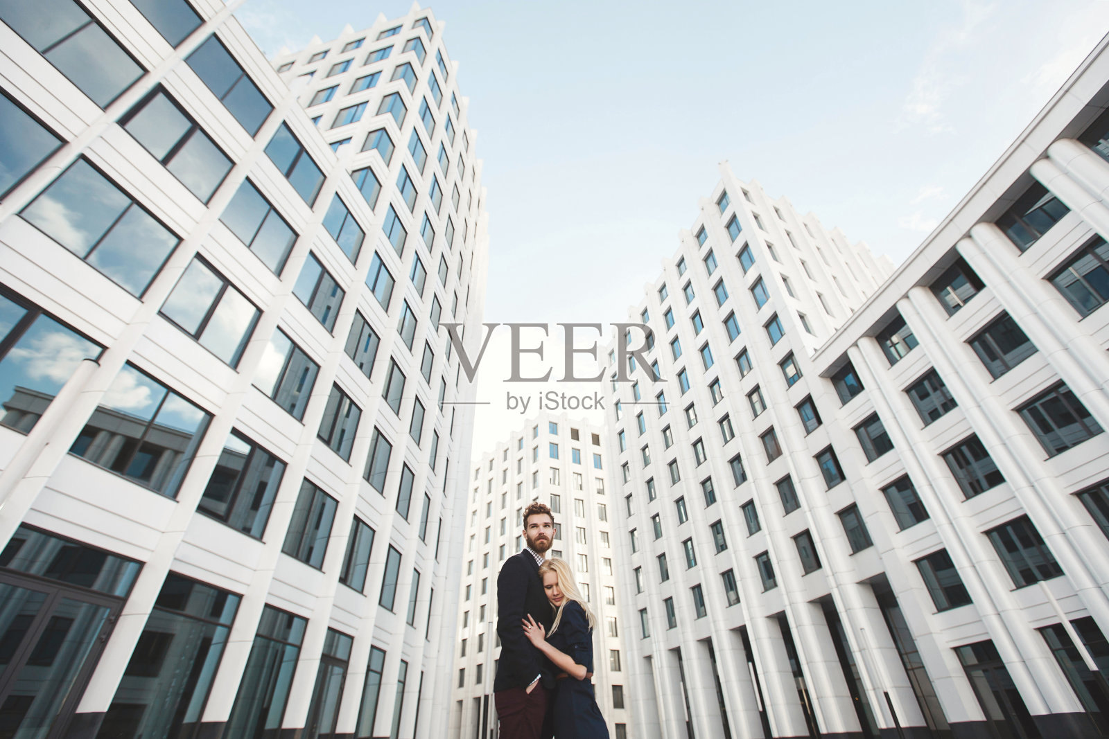 爱情故事。男孩拥抱了女孩。玻璃建筑。照片摄影图片