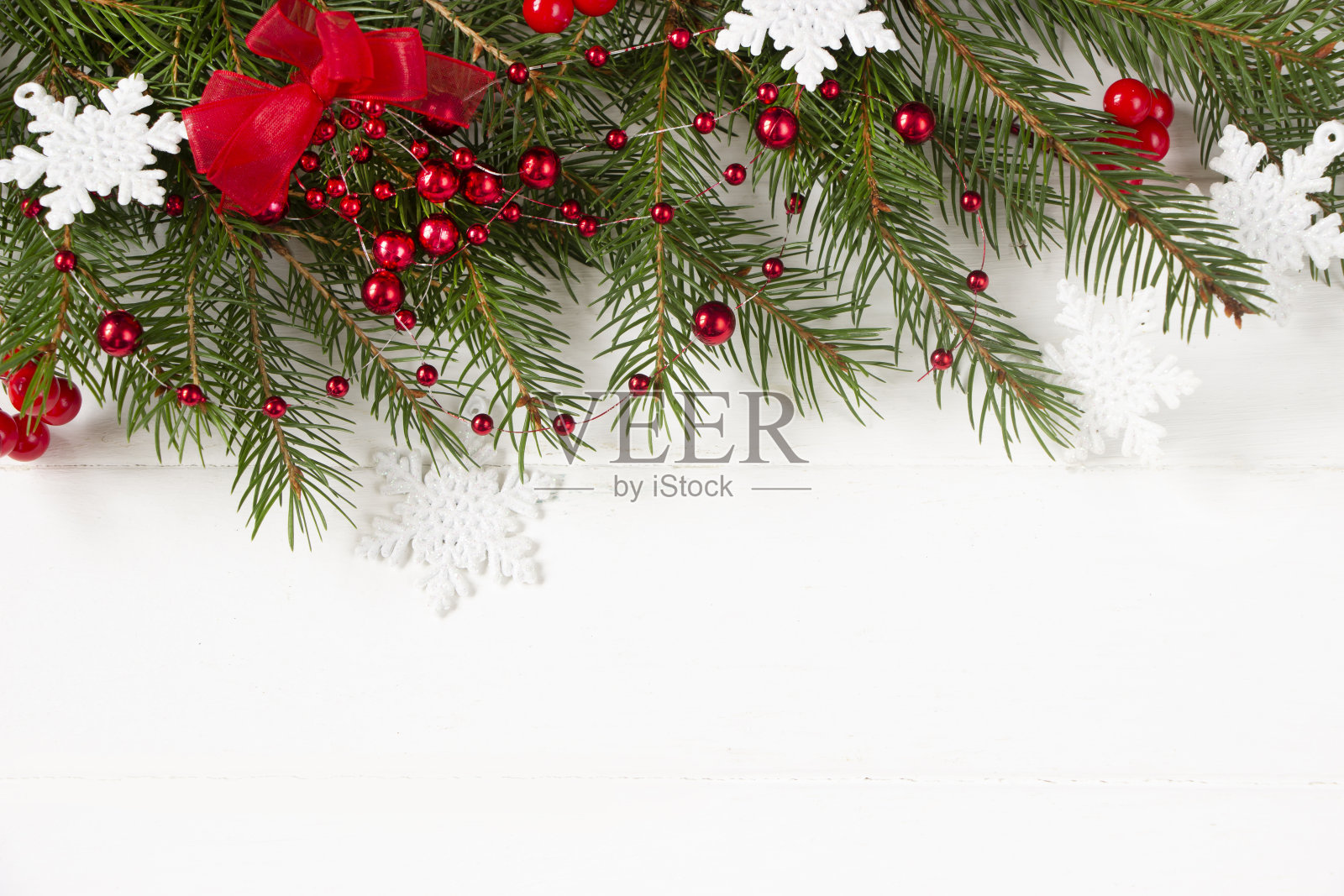 圣诞模板-树枝，白色的雪花，红色的蝴蝶结，浆果在白色的木制背景。圣诞背景为贺卡，广告产品，品牌，行动，销售照片摄影图片