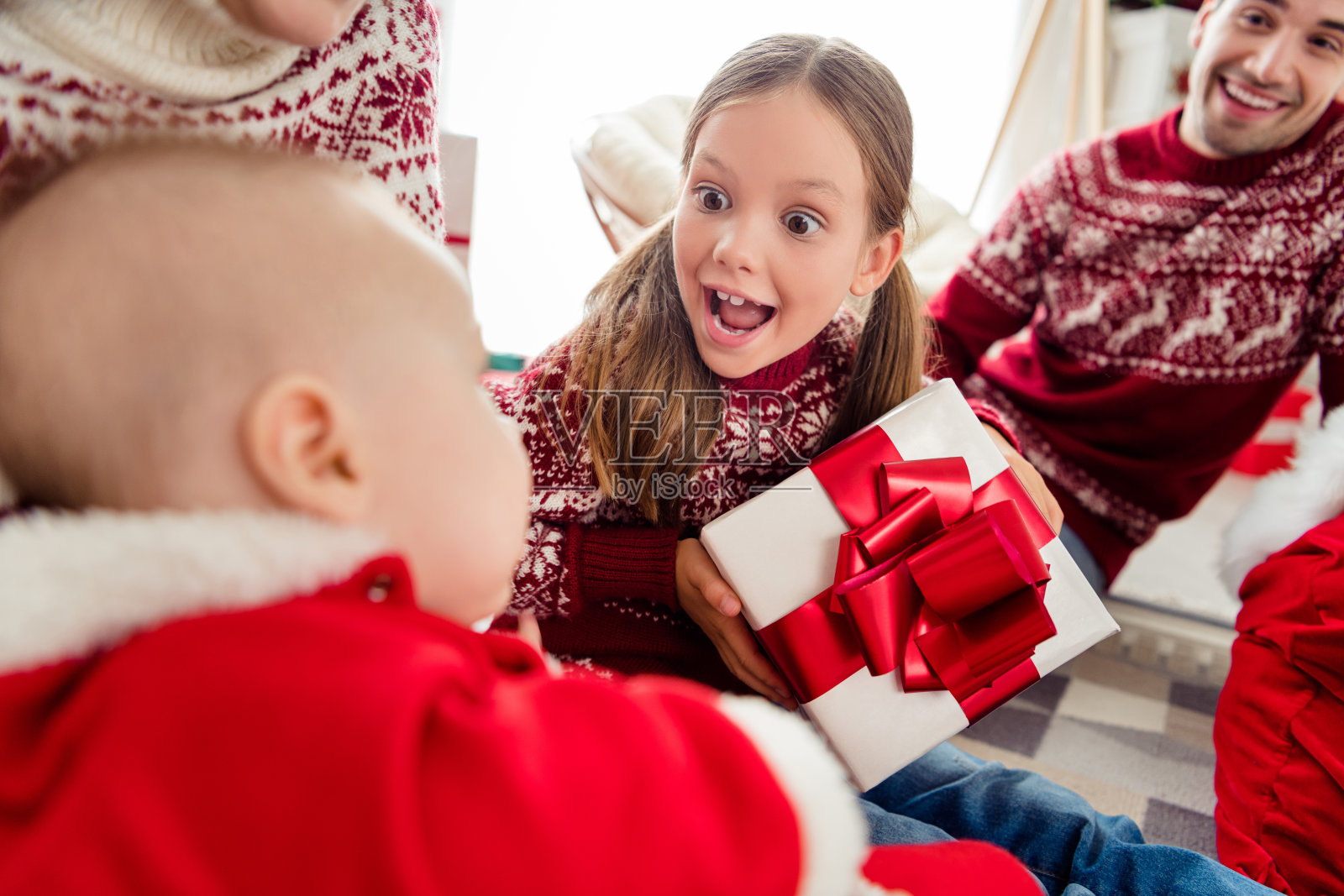 照片的甜蜜印象大家庭穿着新年套衫微笑得到礼物在室内的房子的房间照片摄影图片