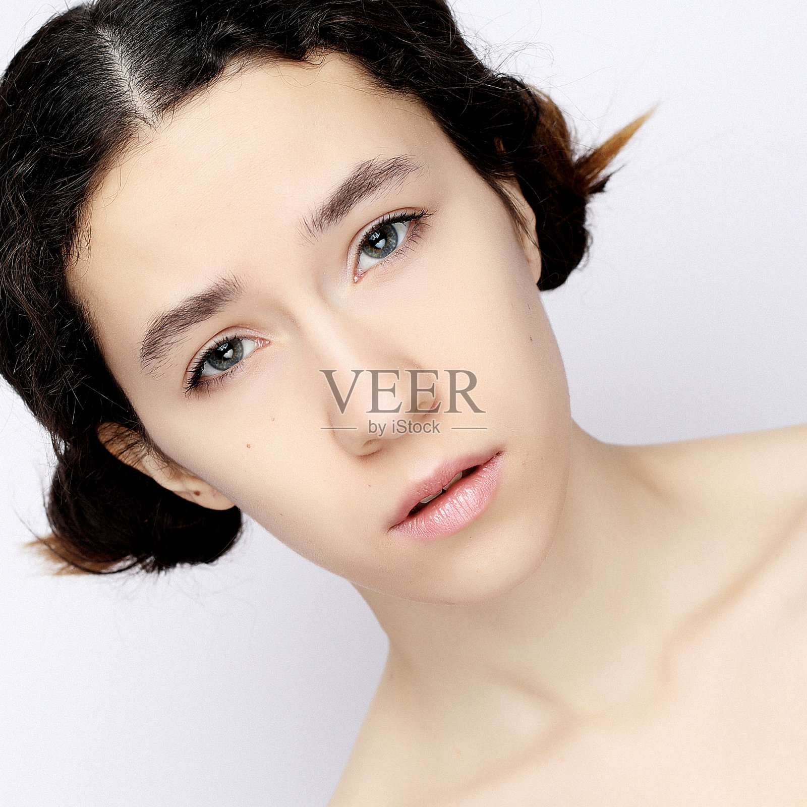 一个兴高采烈的年轻女孩在白色背景下看着照相机照片摄影图片