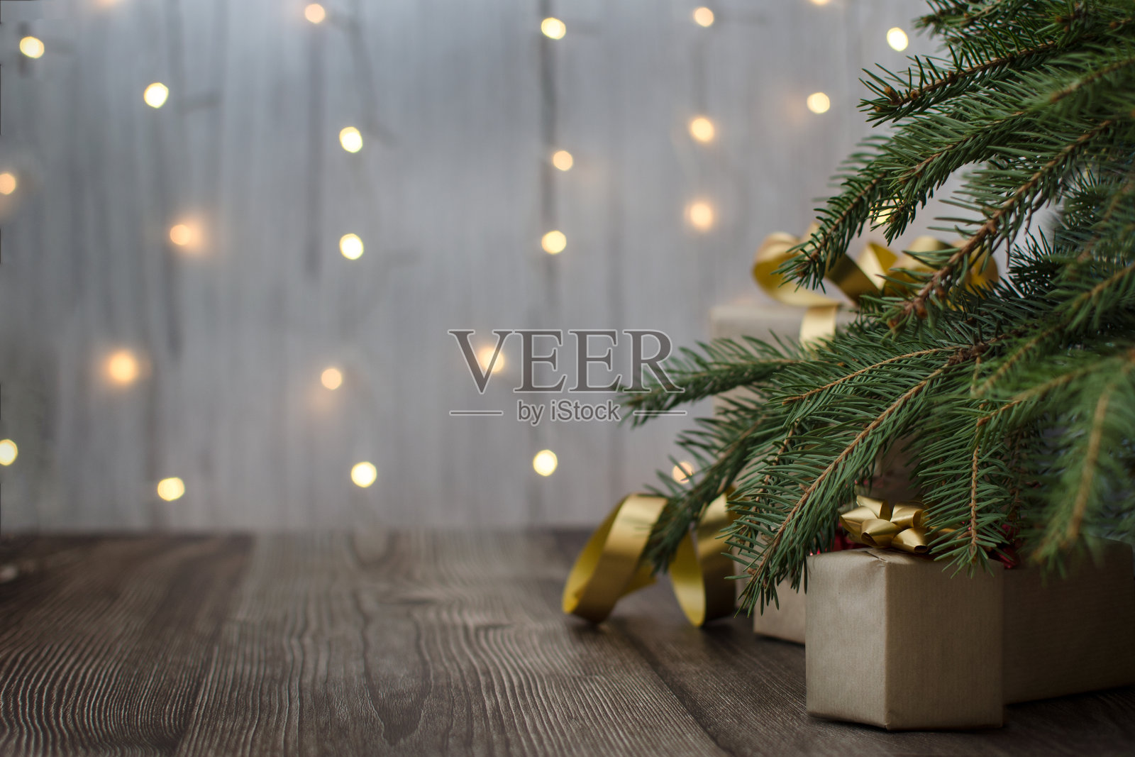圣诞节的背景。圣诞树下的礼物。木质地板。背景是花环灯。圣诞节的气氛照片摄影图片