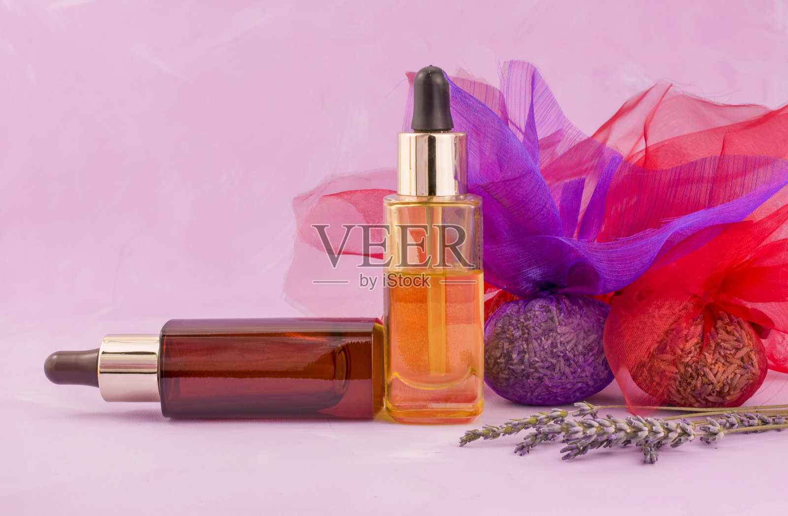 干薰衣草和精油在粉红色背景小瓶照片摄影图片