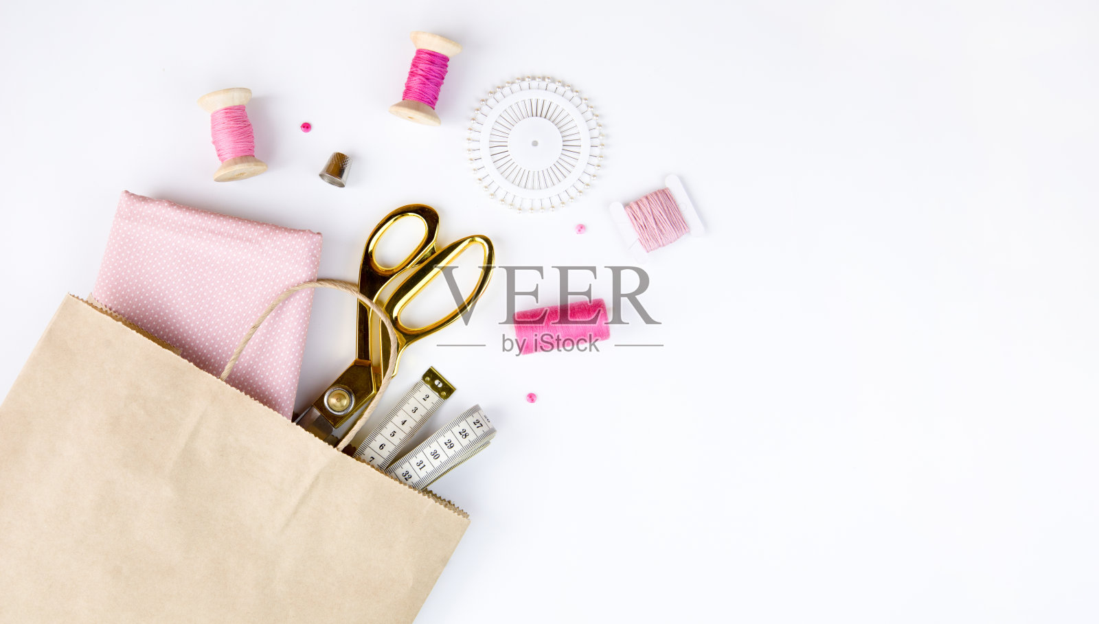 剪刀，线，针和棉织品在一个工艺袋里。照片摄影图片