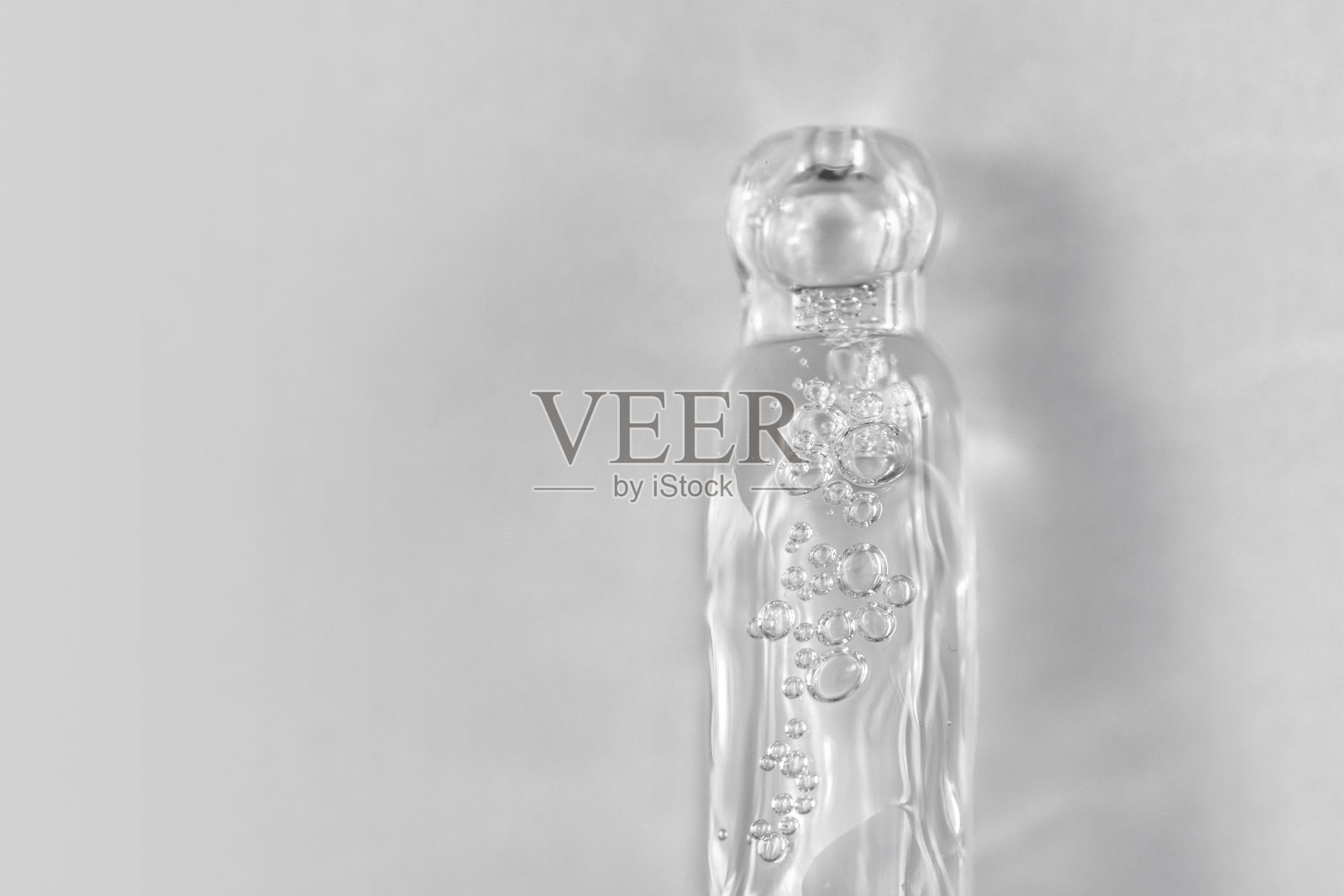 蓝色单色背景下透明质酸液吸管。化妆品和保健概念特写照片摄影图片