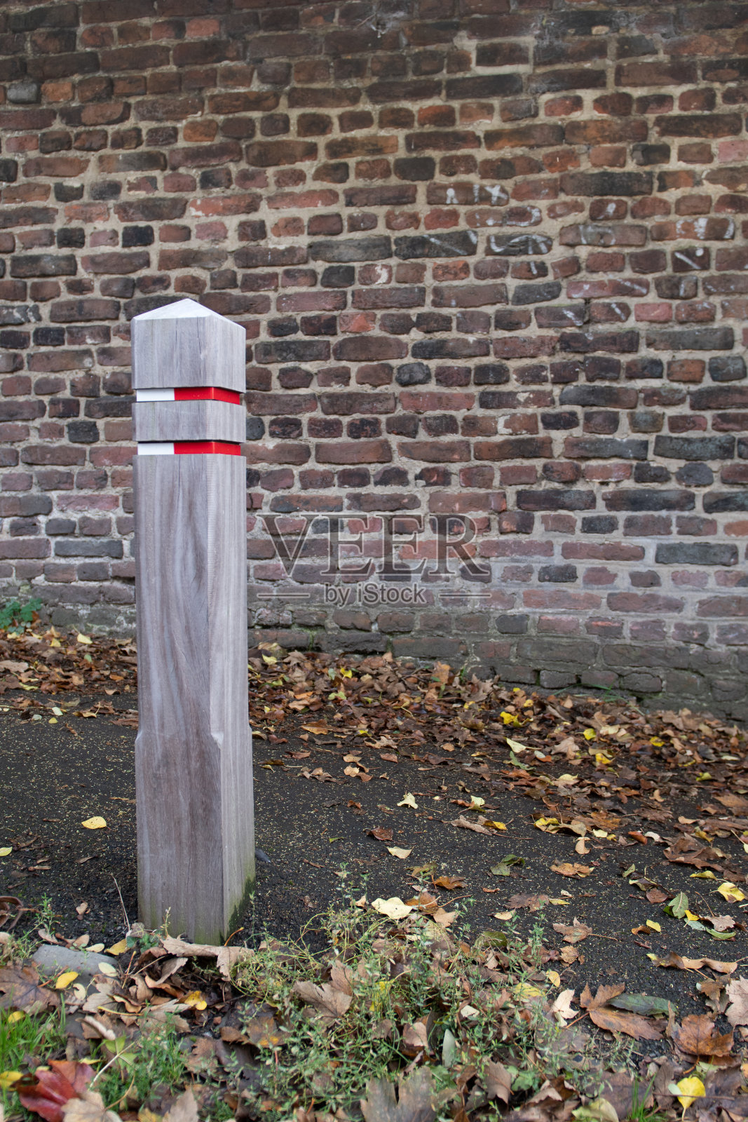 人行道上的木制界桩有红色和白色标签照片摄影图片