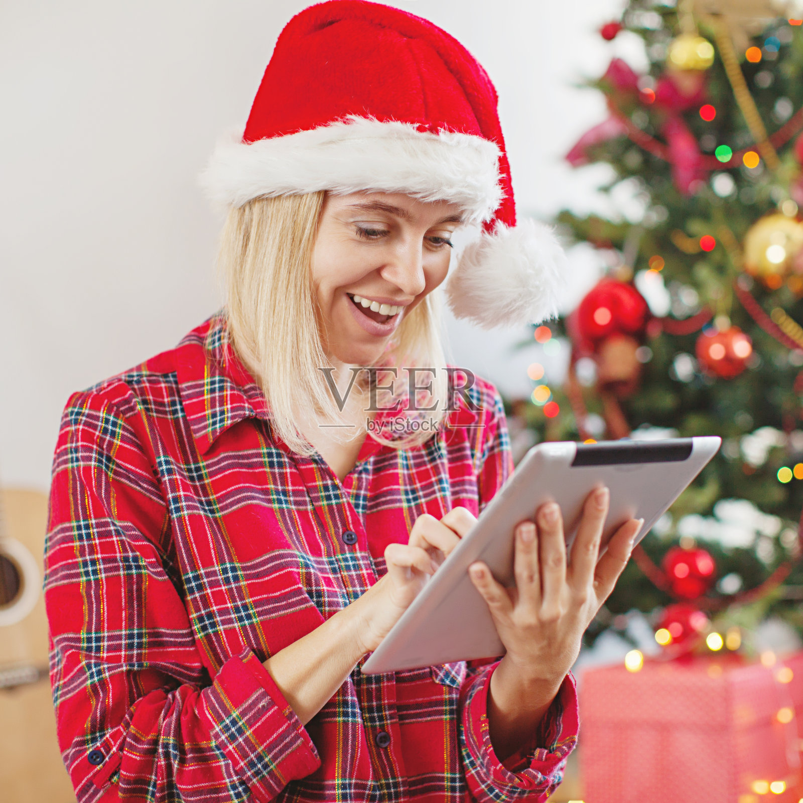 一个女人在圣诞树前使用平板电脑照片摄影图片
