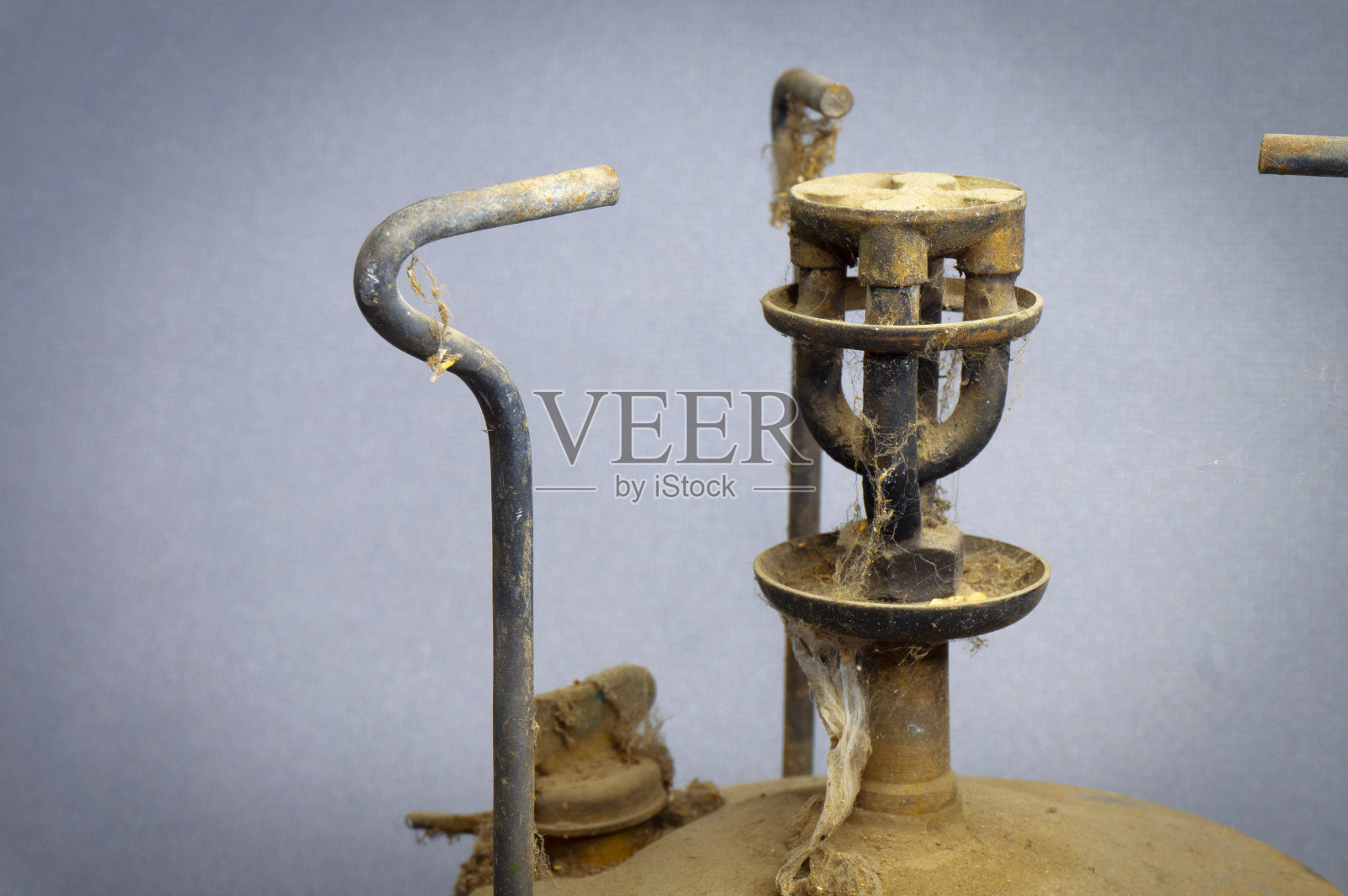 灰色背景上满是灰尘和蜘蛛网的老式煤油车照片摄影图片