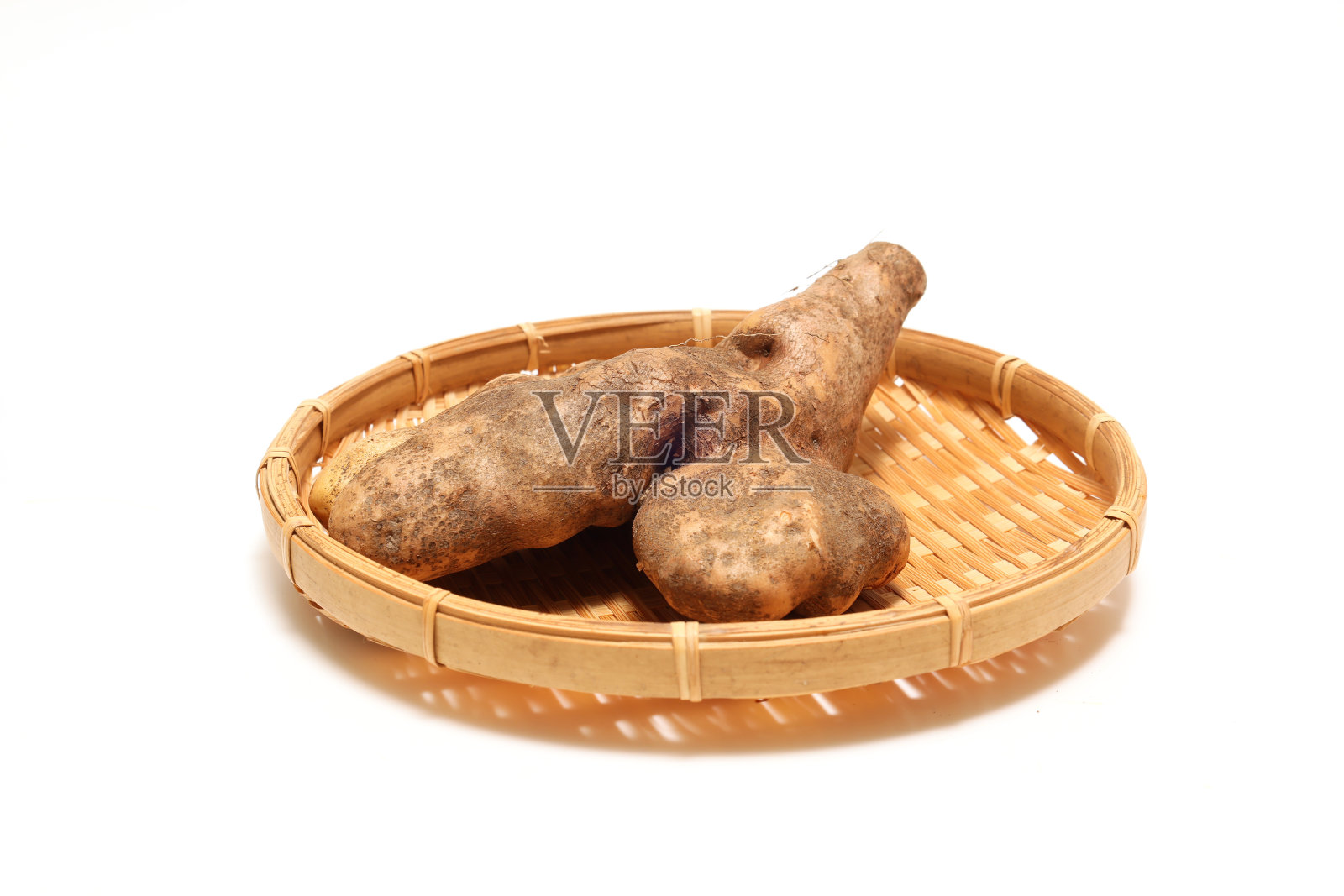 竹滤锅上的山药被隔离在白色的背景上。照片摄影图片