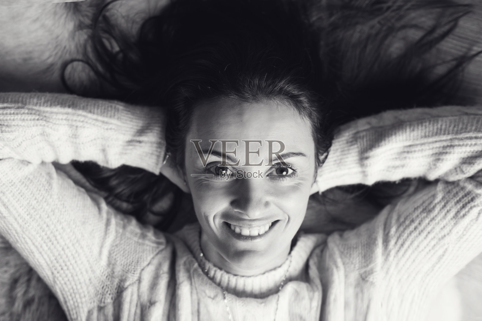 一位中年妇女，躺在一间木屋的地上，面带微笑照片摄影图片