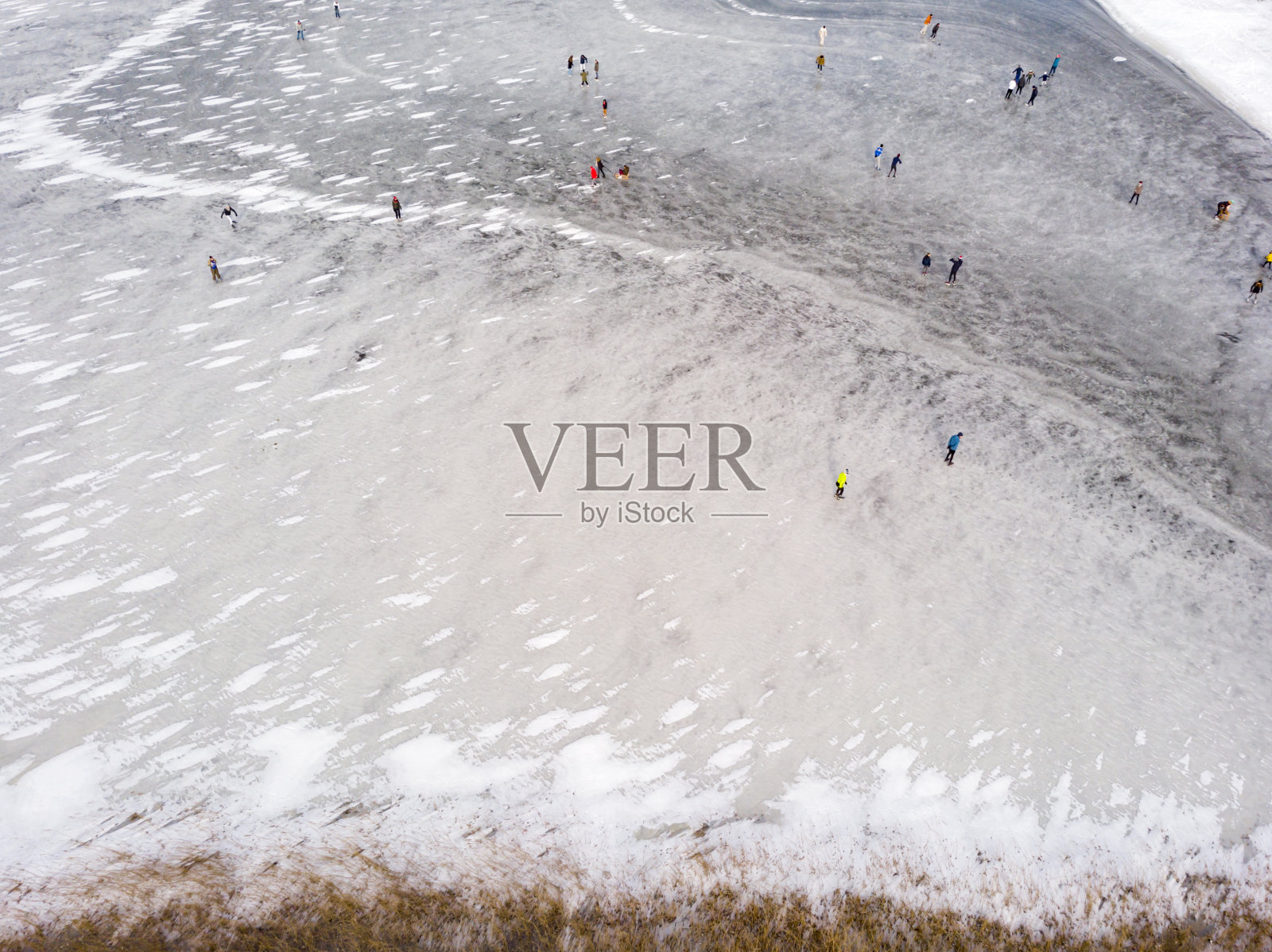 在荷兰，冬天在结冰的湖面上滑冰的人们照片摄影图片