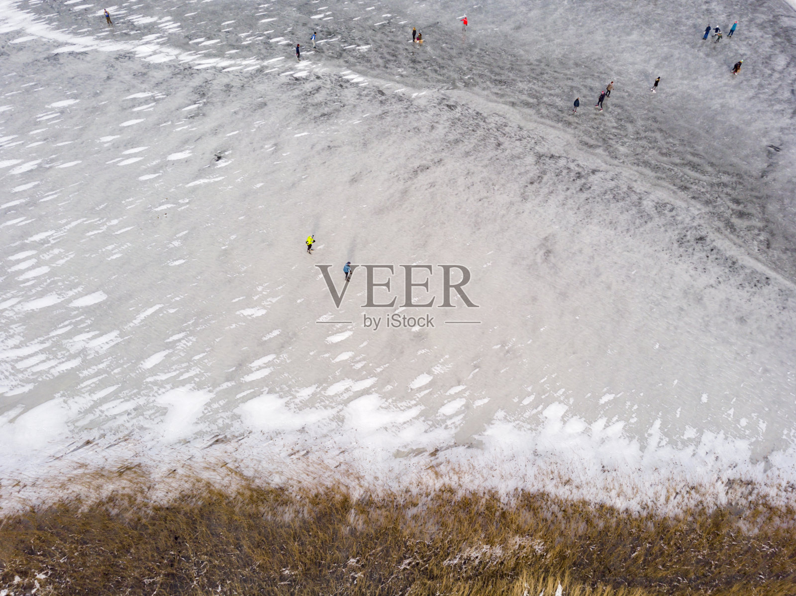 在荷兰，冬天在结冰的湖面上滑冰的人们照片摄影图片