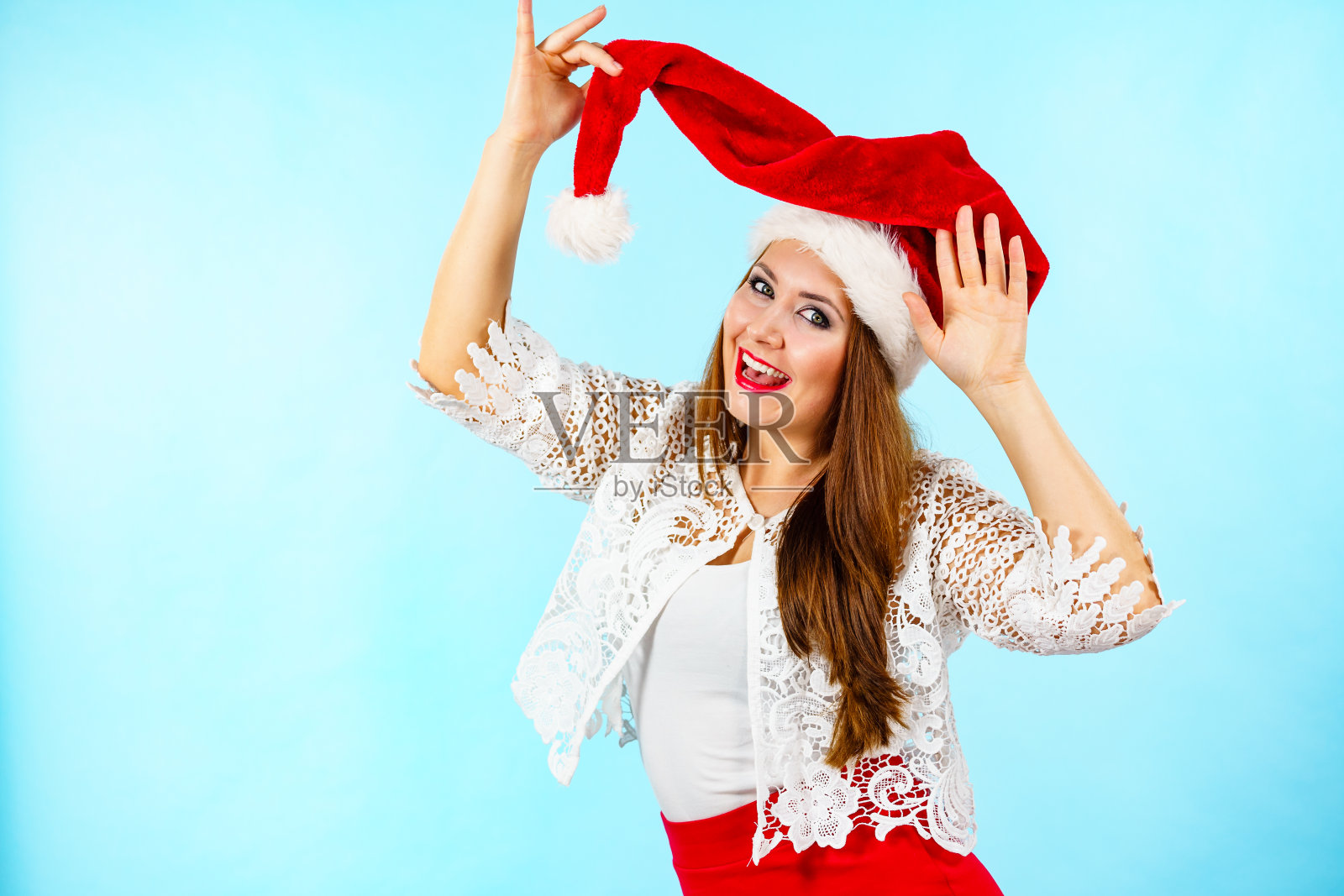 快乐的女人在圣诞老人的帽子照片摄影图片