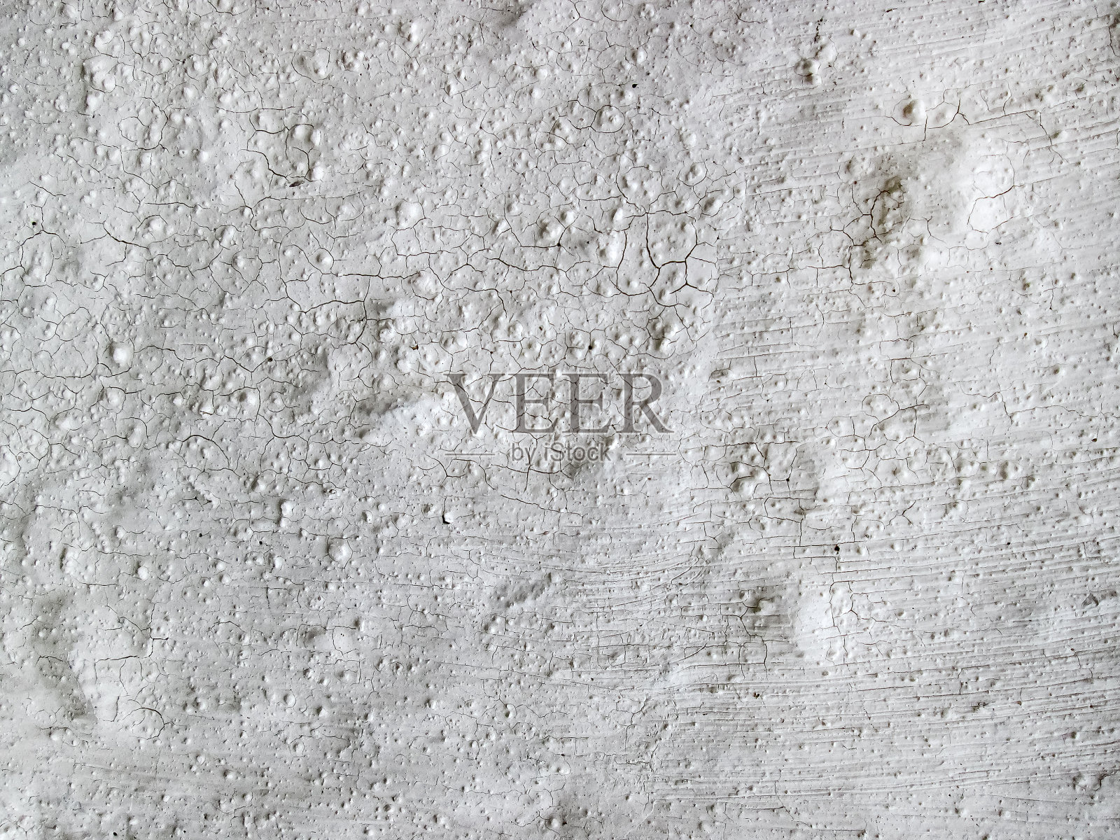有凹痕和划痕的开裂的白墙。白色纹理与自然破坏的建筑材料。照片摄影图片