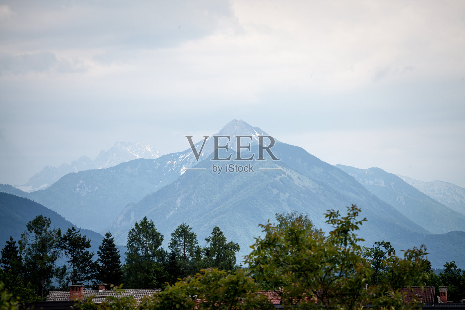 Hochstuhl山的全景，也被称为Veliki Stol vrh，在斯洛文尼亚和奥地利之间，日落期间，在云层之上的顶峰。它是朱利安阿尔卑斯山脉的主要山脉，位于卡拉万克斯山脉。照片摄影图片