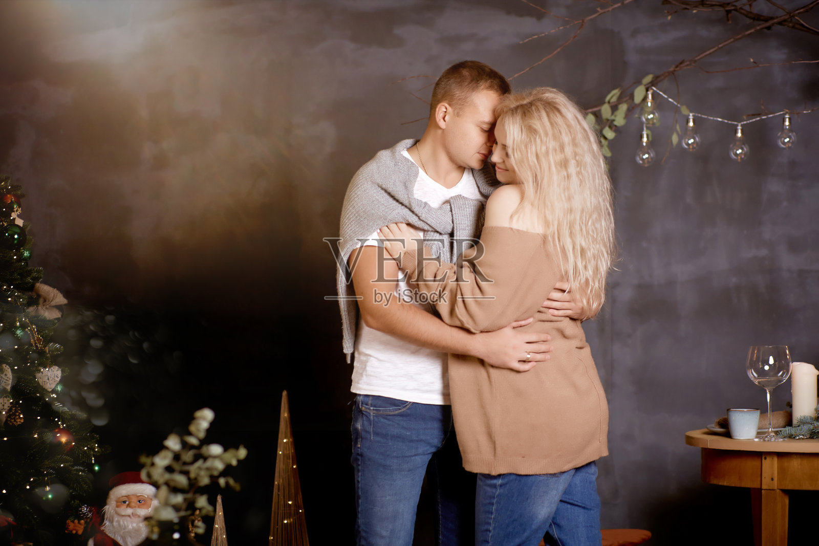 倾心夫妇的男人和金发女人在审美舒适的室内与节日圣诞树。坦诚,真实的时刻。好心情，一起玩。圣诞节的爱情故事。本空间照片摄影图片