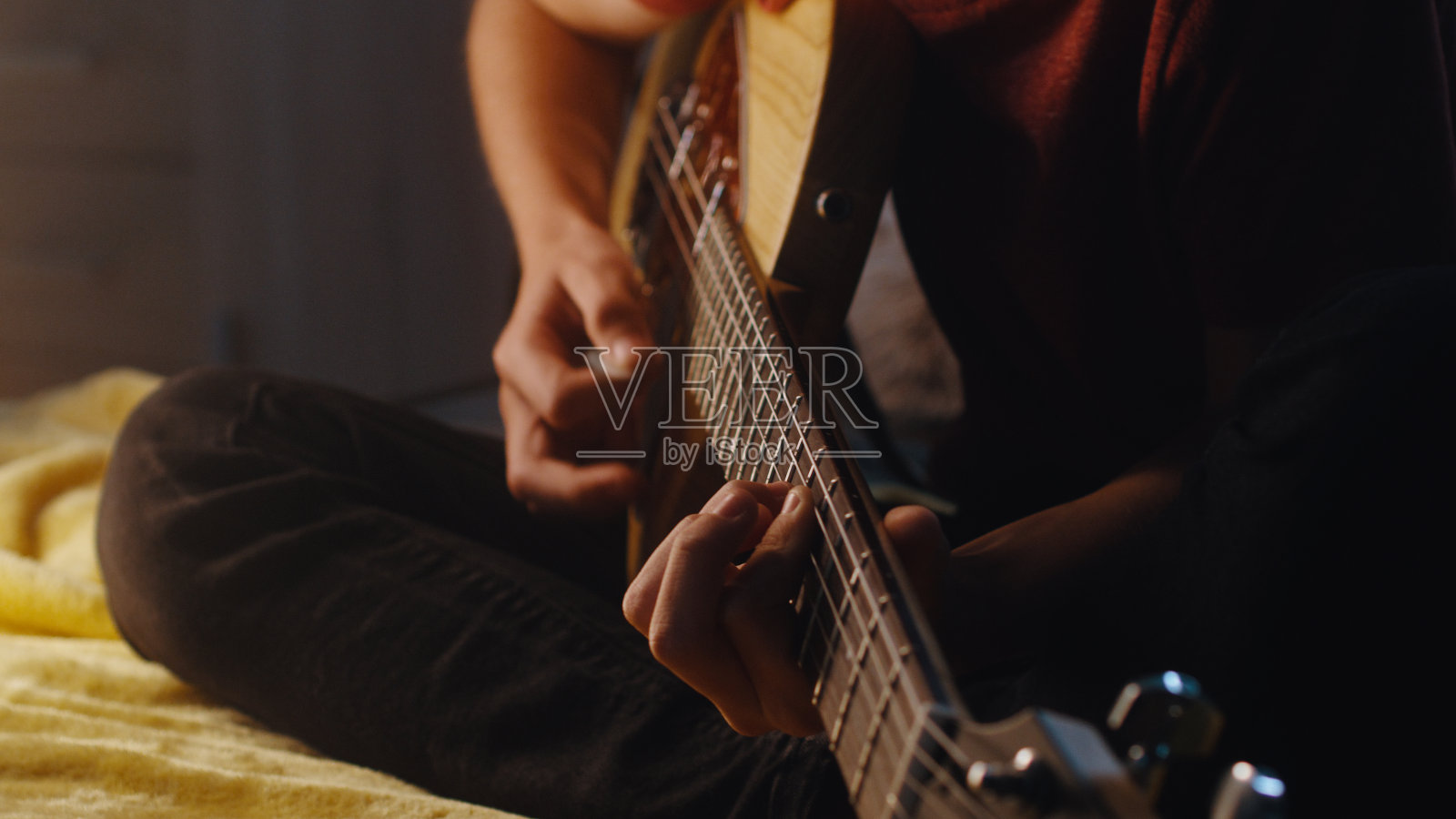 少年音乐家在晚上弹吉他照片摄影图片