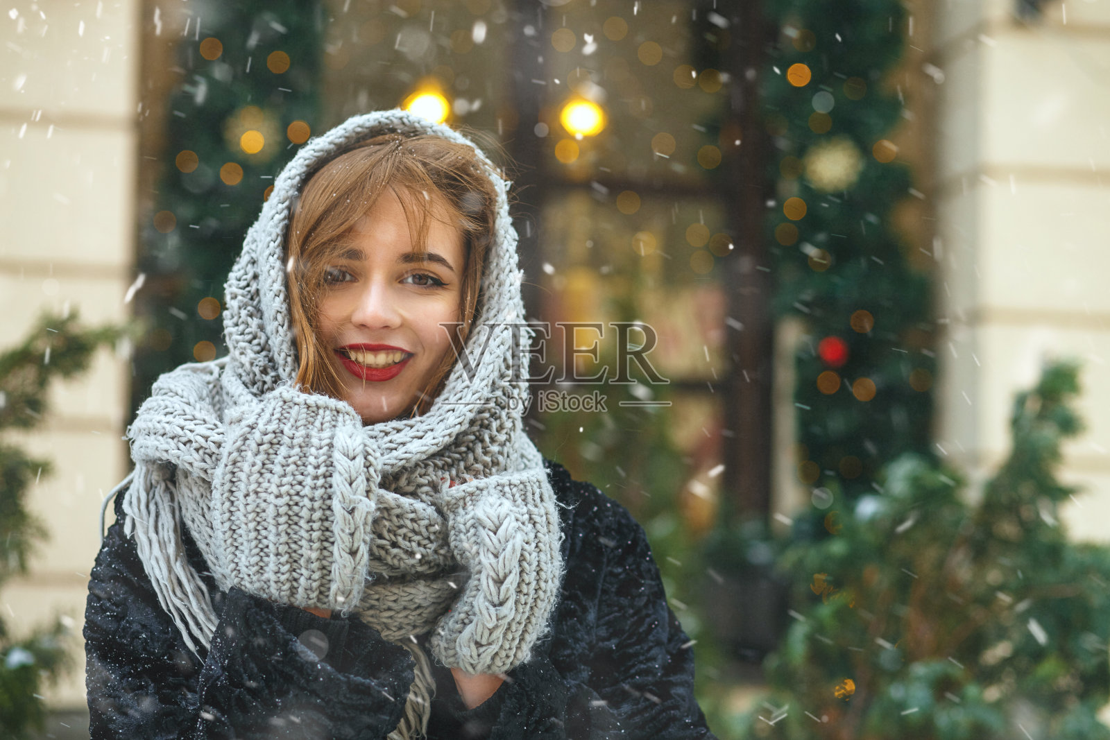 快乐的女士在城市里享受下雪的天气照片摄影图片