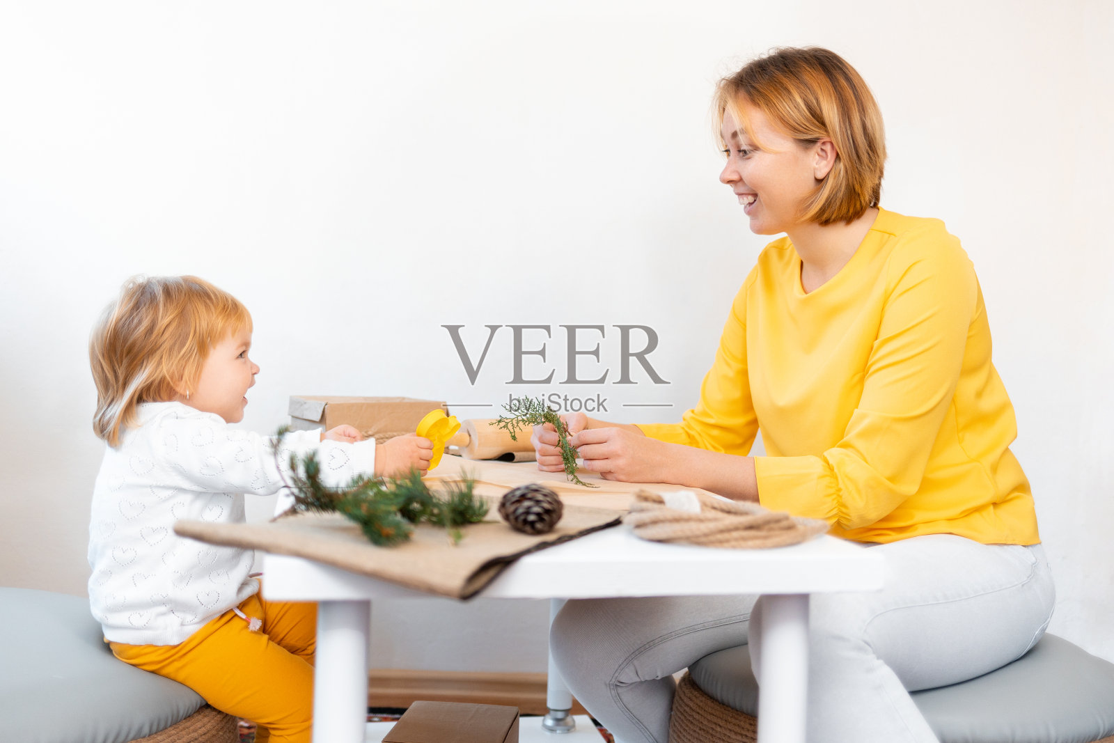 快乐的妈妈和孩子正在做圣诞装饰品。副本的空间。圣诞假期照片摄影图片