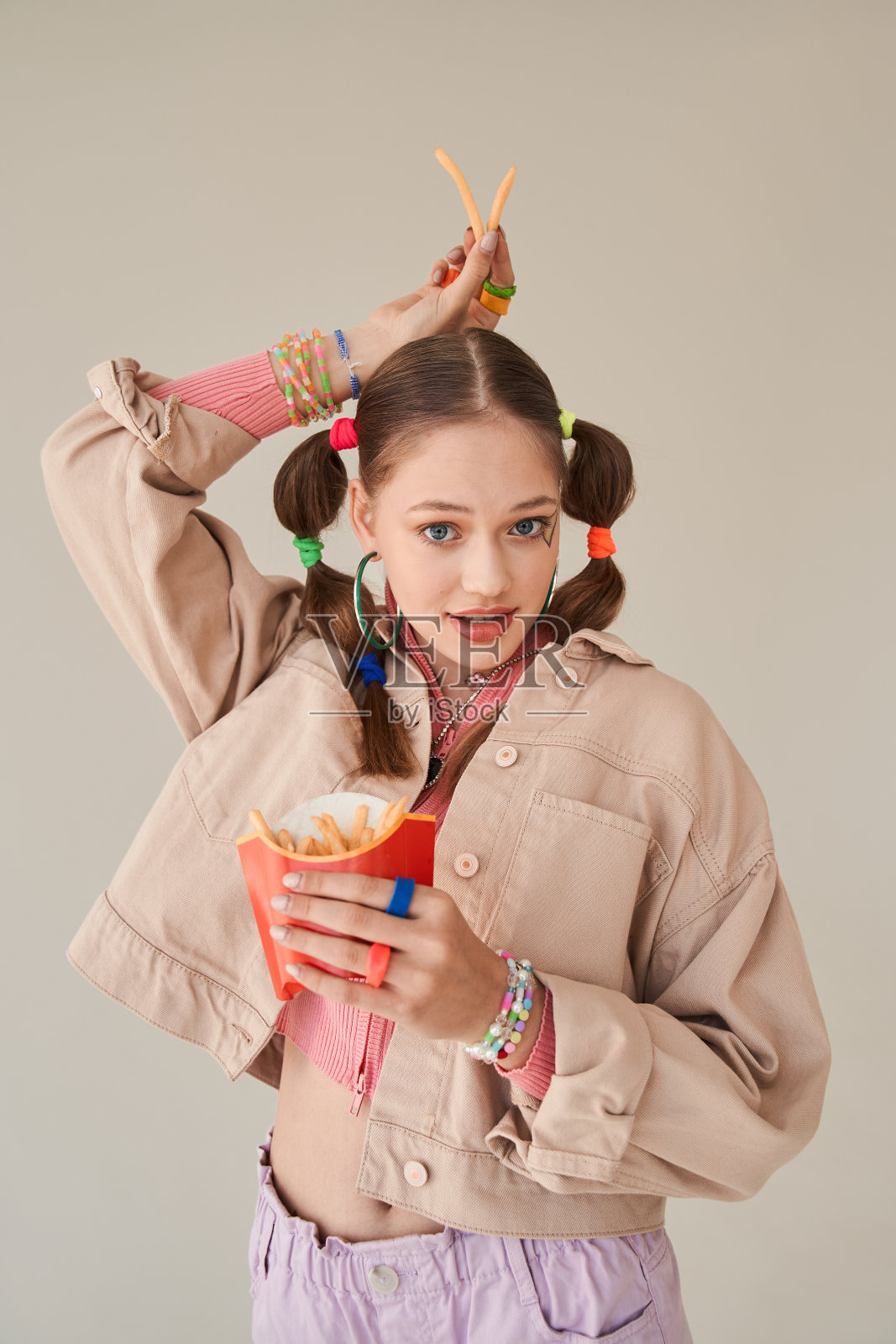 有趣的十几岁女孩鬼混，而与炸薯条在工作室摆姿势照片摄影图片