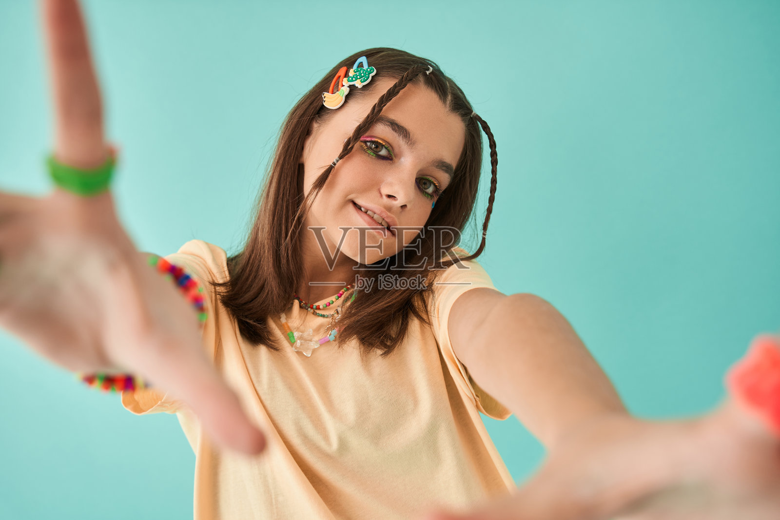 女孩穿着创意配饰，对着镜头伸出手微笑照片摄影图片