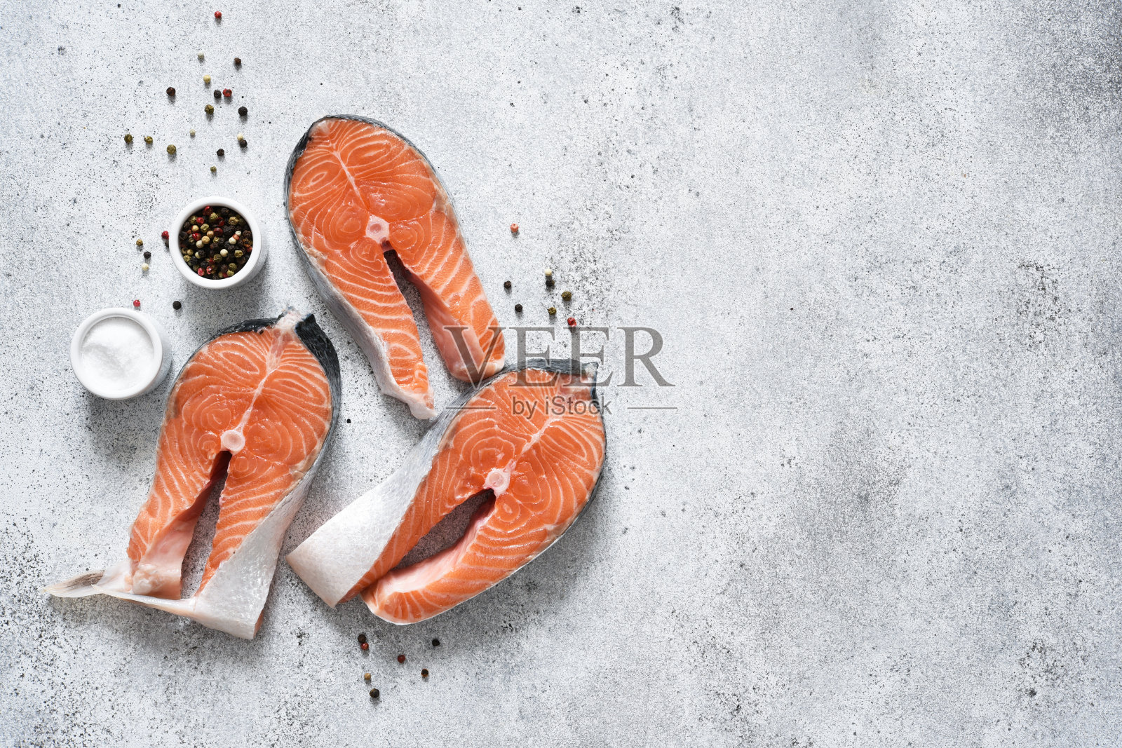 鲑鱼牛排。在混凝土的背景上搭配香料的新鲜红鱼。照片摄影图片