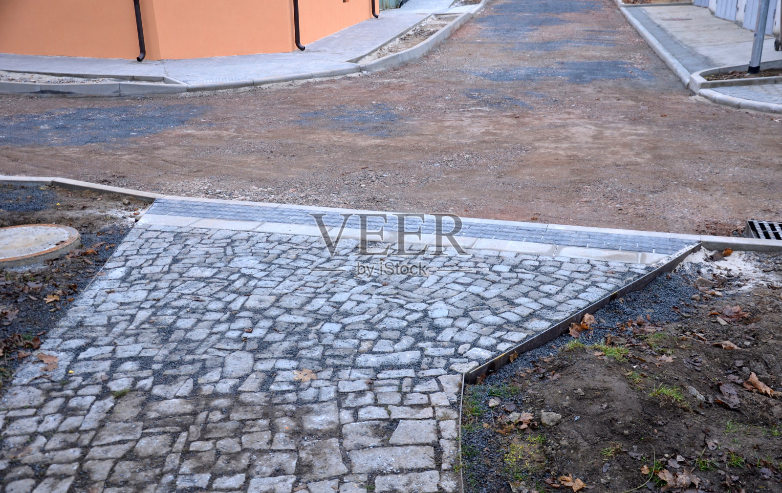 沥青路面准备。在沥青机到达之前，底层的碎石或回收建筑必须适当压实。运河和周围的路沿略高于地面照片摄影图片