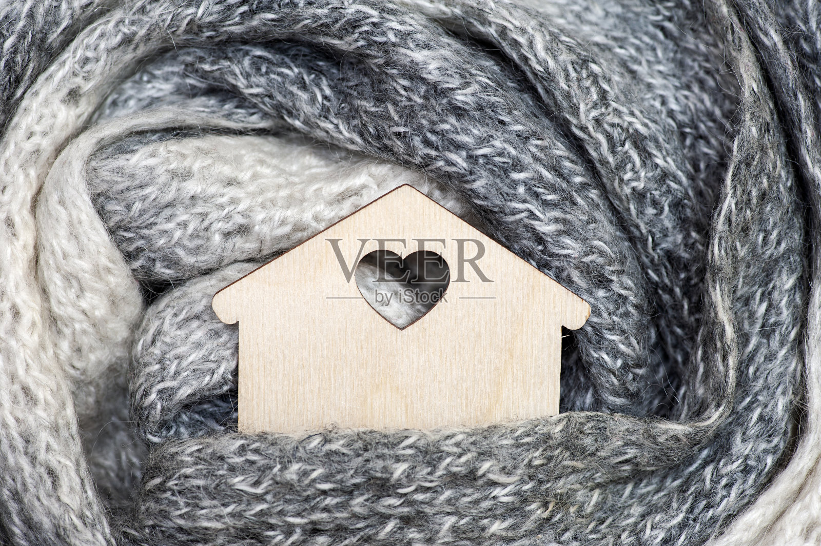 温暖的家的概念。用柔软的围巾包裹温馨环保的家。照片摄影图片