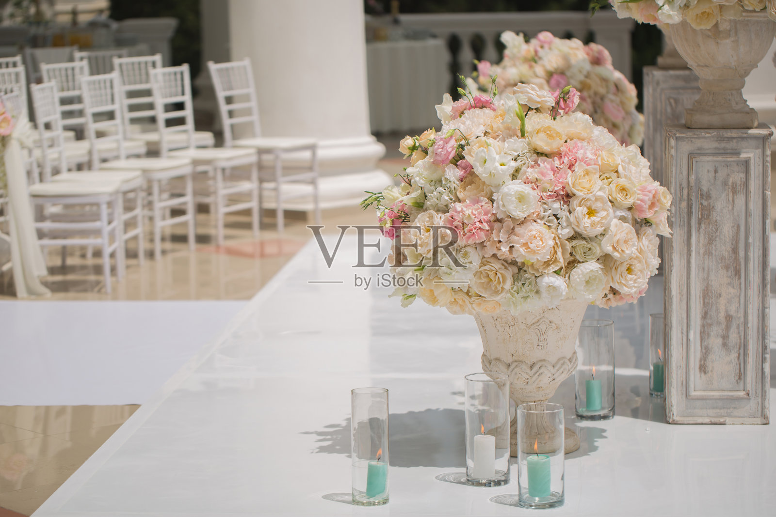 在婚礼拱门的背景上，花瓶里美丽的玫瑰花束。为婚礼做了漂亮的准备。照片摄影图片