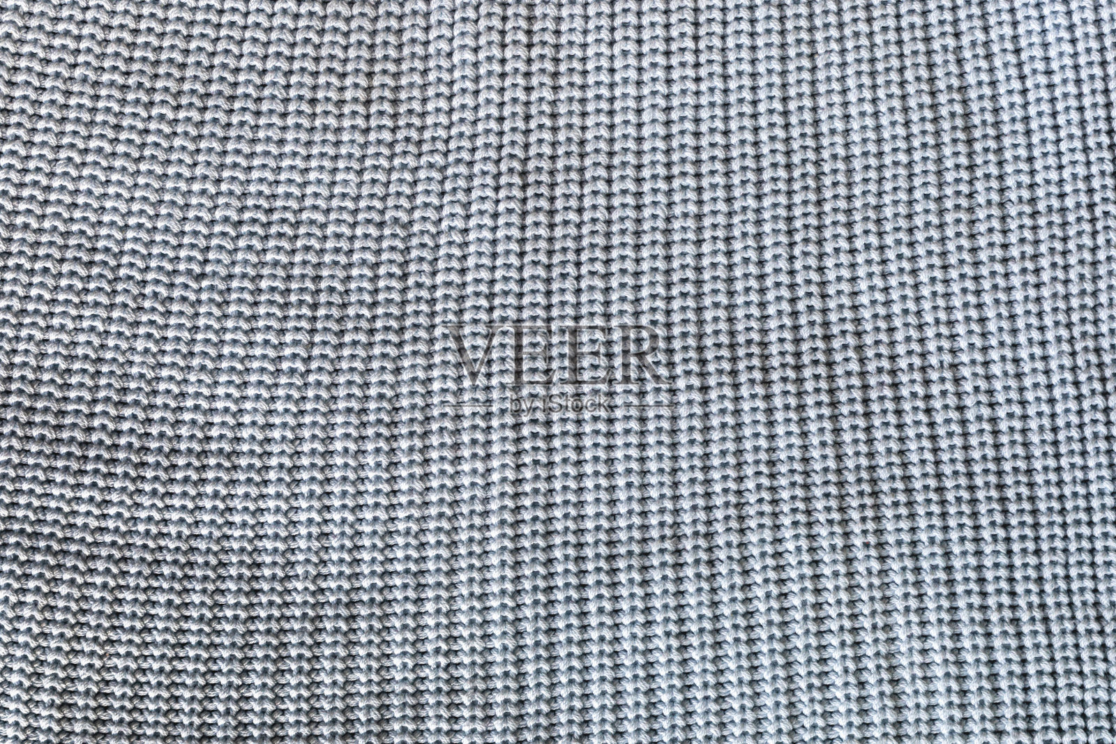 在一件蓝色毛衣的表面上平行的相同的针脚照片摄影图片