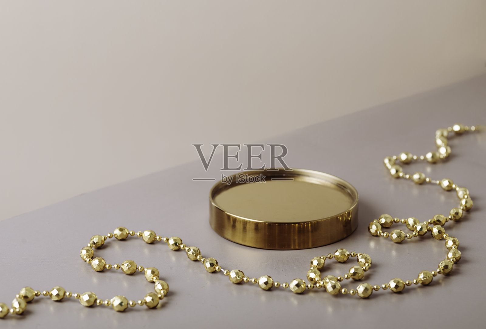 金色的讲台与新年装饰在米黄色的背景。新年的平台。副本的空间。节日的背景。照片摄影图片