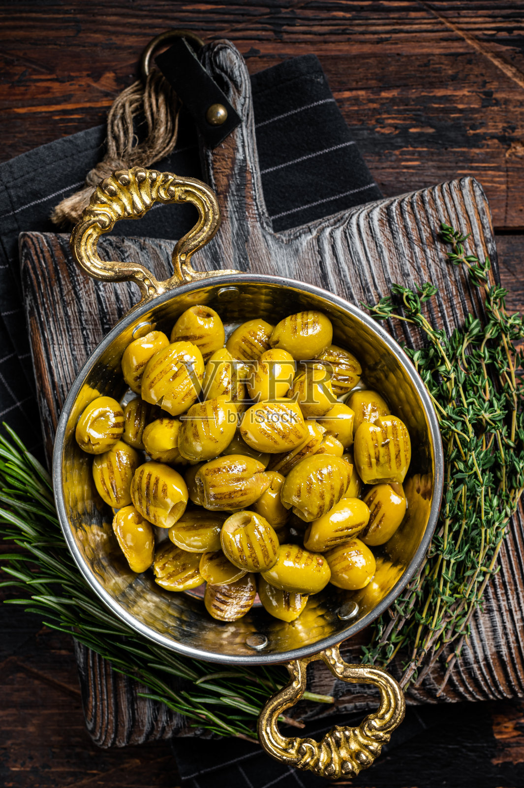 土耳其式烤橄榄，加入橄榄油和香草。木制背景。俯视图照片摄影图片