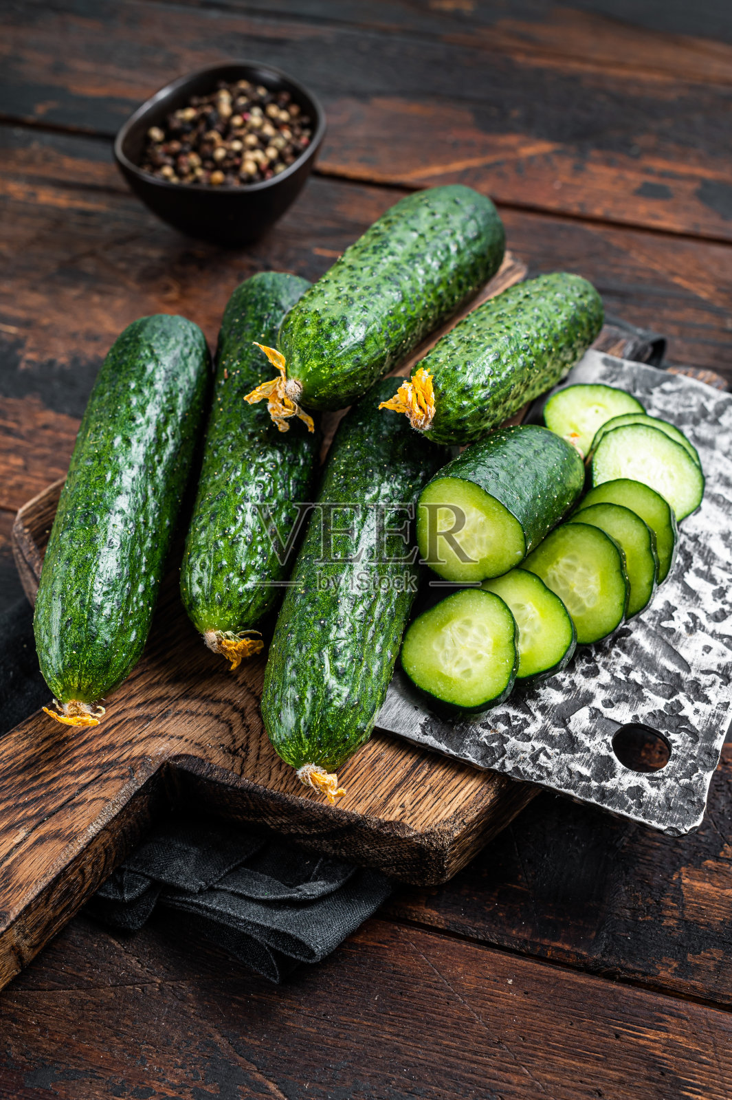 切成薄片的黄瓜放在木板上。深色木制背景。俯视图照片摄影图片
