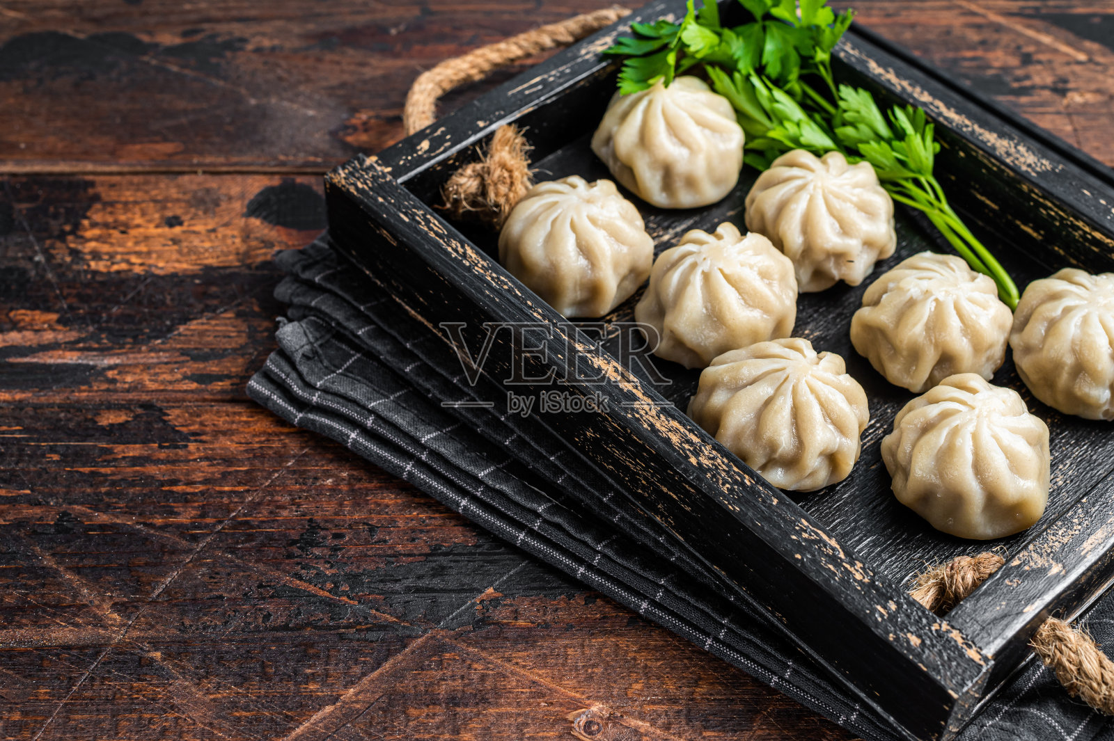 木托盘里的蘑菇饺子和香草。深色木制背景。前视图。本空间照片摄影图片