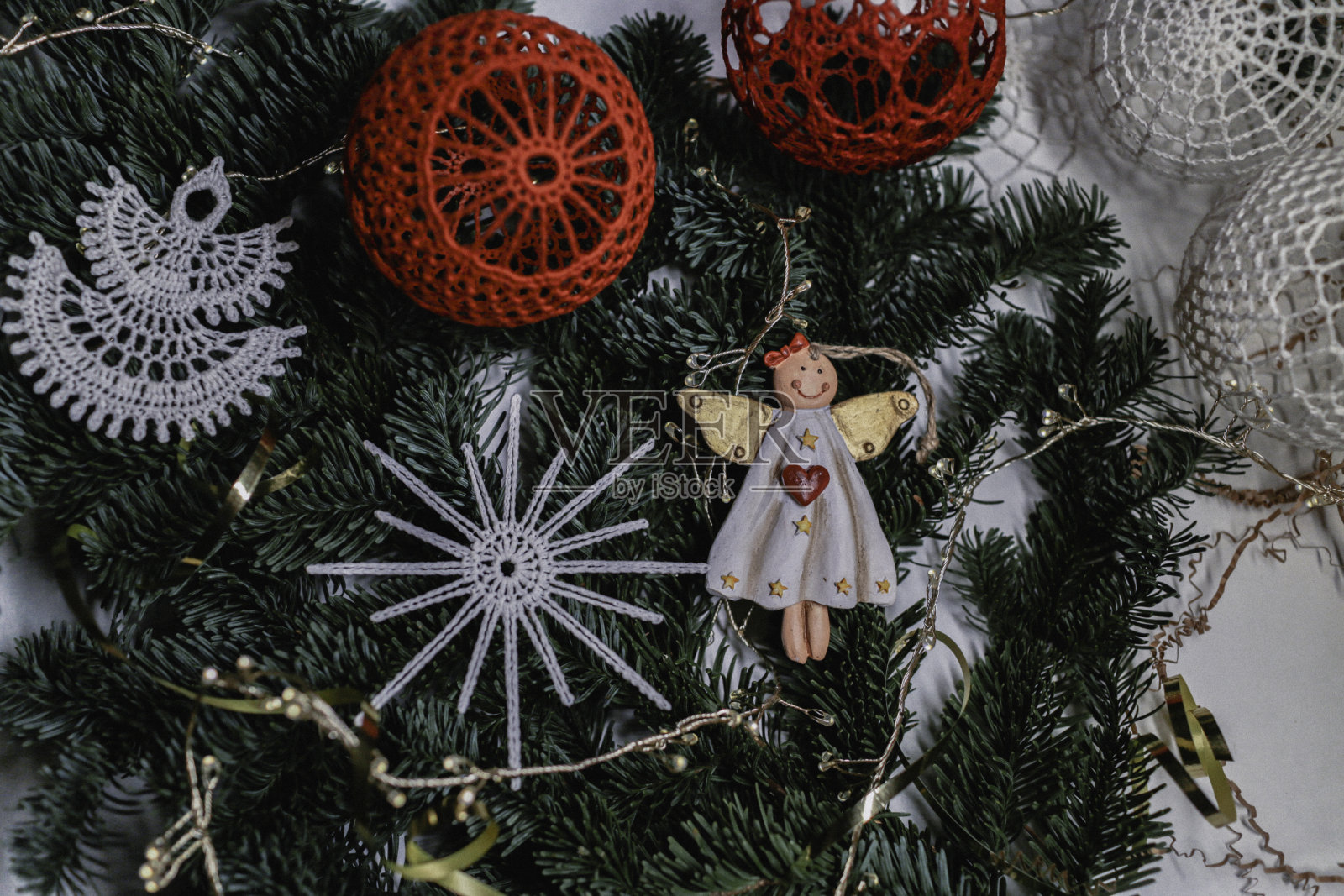 圣诞天使和球编织在流结风格的圣诞树的背景上，手工装饰在生态风格，手特写，俯视图照片摄影图片