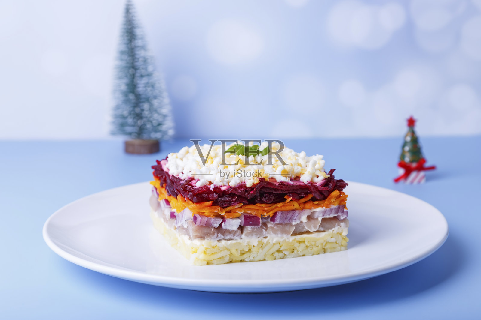 皮大衣下裹着鲱鱼沙拉。传统的俄罗斯多层沙拉，由鲱鱼、甜菜、土豆、胡萝卜和鸡蛋组成。特写,微型新照片摄影图片