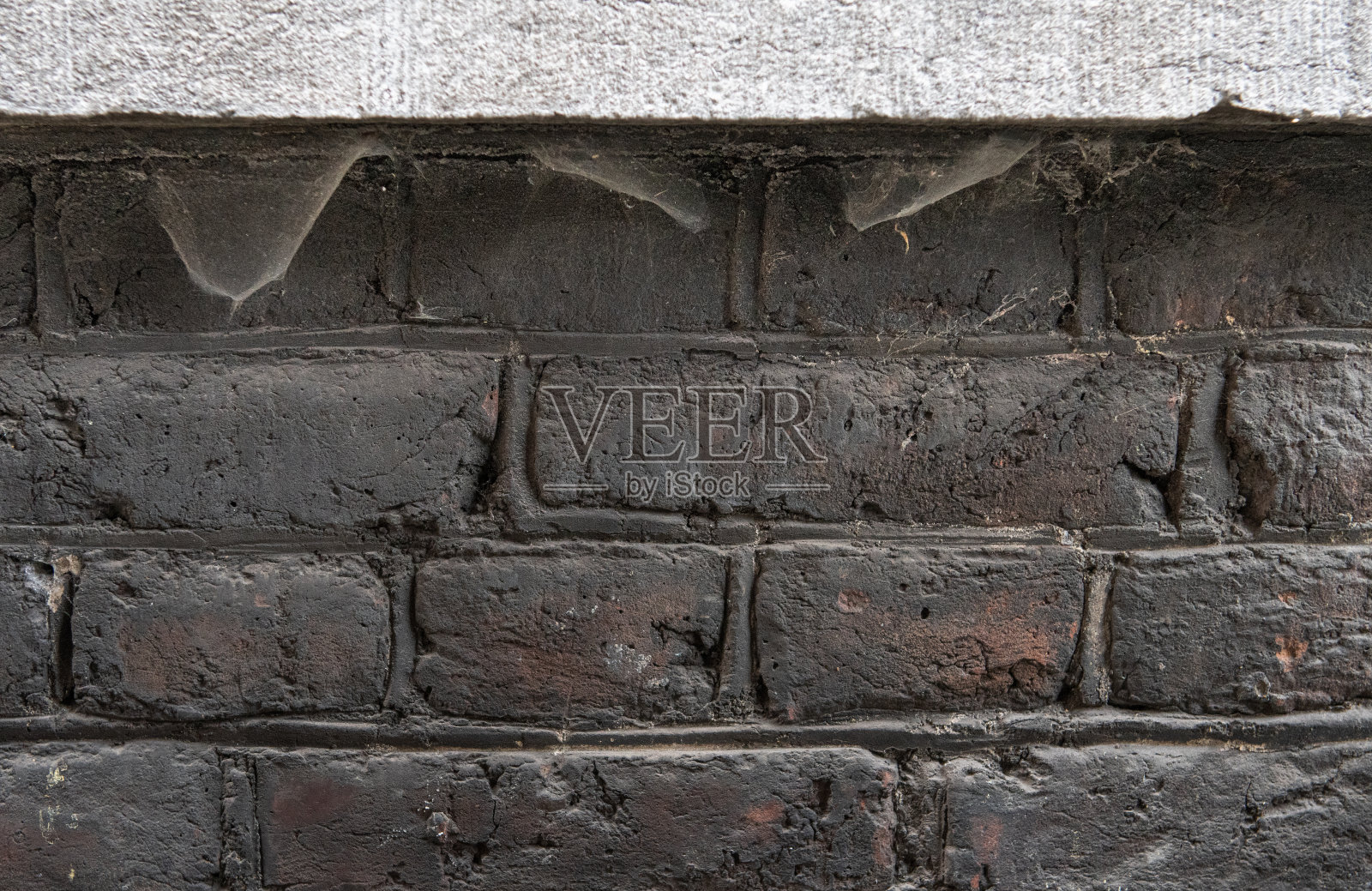 旧窗户上的蜘蛛网。在砖墙背景下的混凝土窗台下照片摄影图片