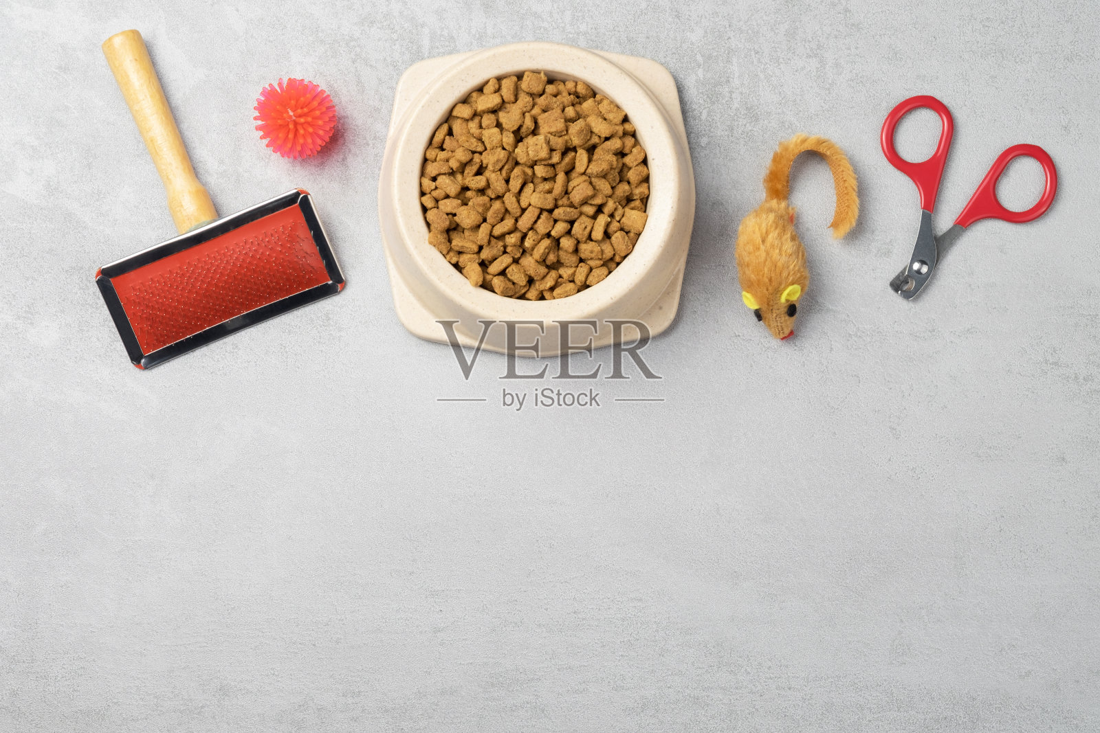 猫用配件:梳子，球，指甲钳，鼠标。宠物护理的概念。灰色背景，复制空间照片摄影图片