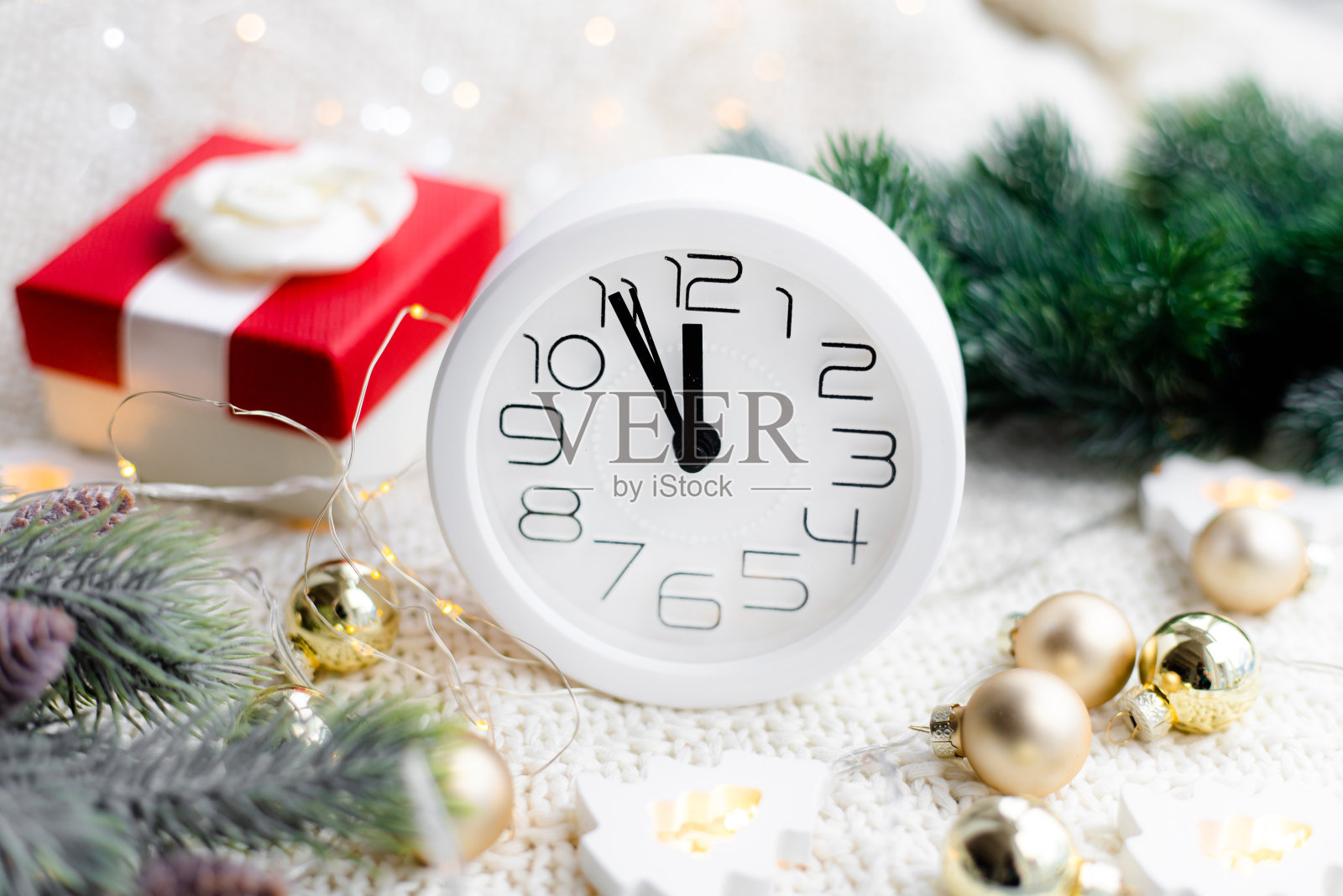 海滩上戴着花环的时钟。一个白色的手表。舒适的氛围。家里舒适。新年和圣诞节。照片摄影图片