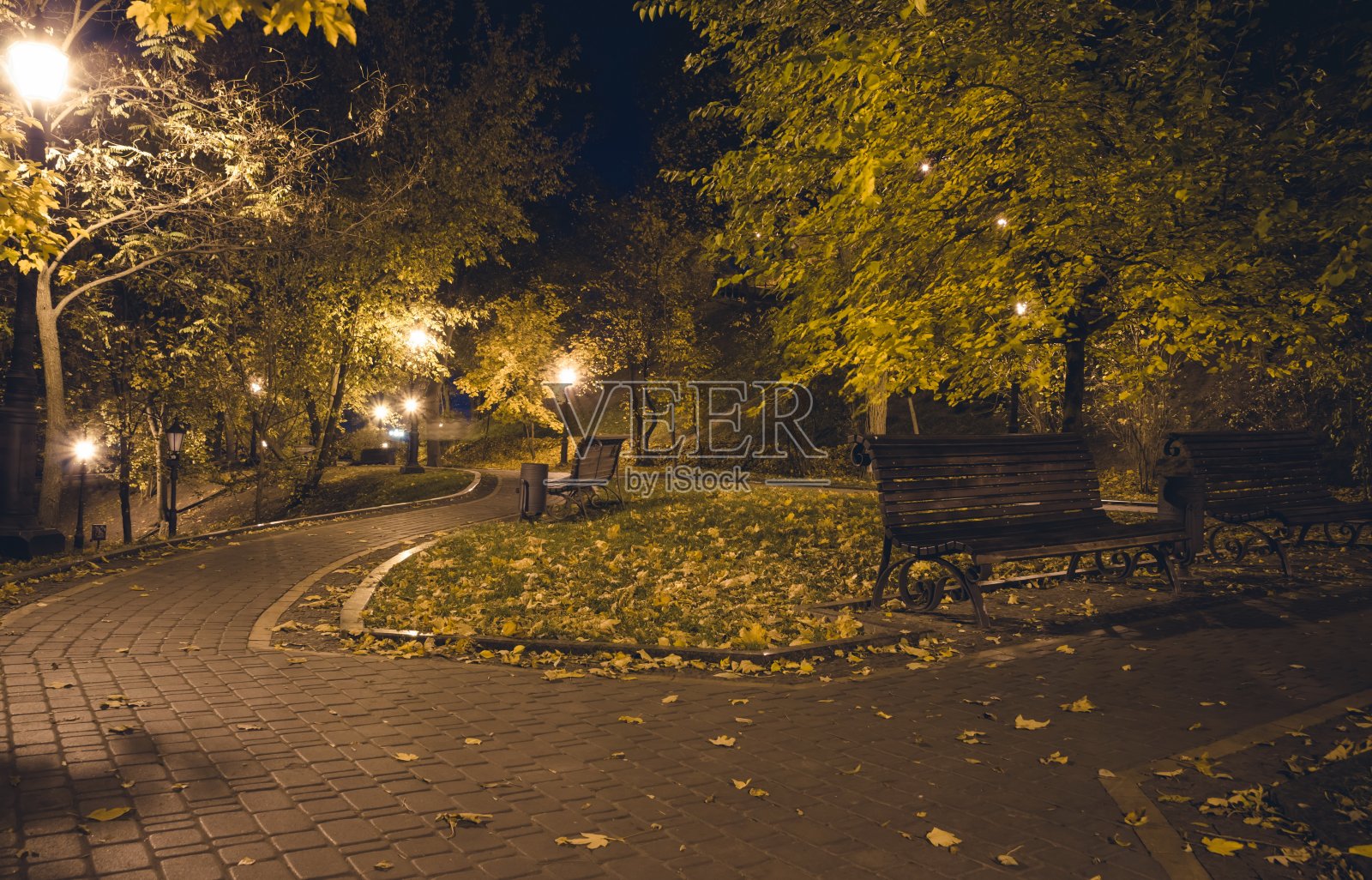 秋夜公园里铺着花灯的小路。板凳上照片摄影图片