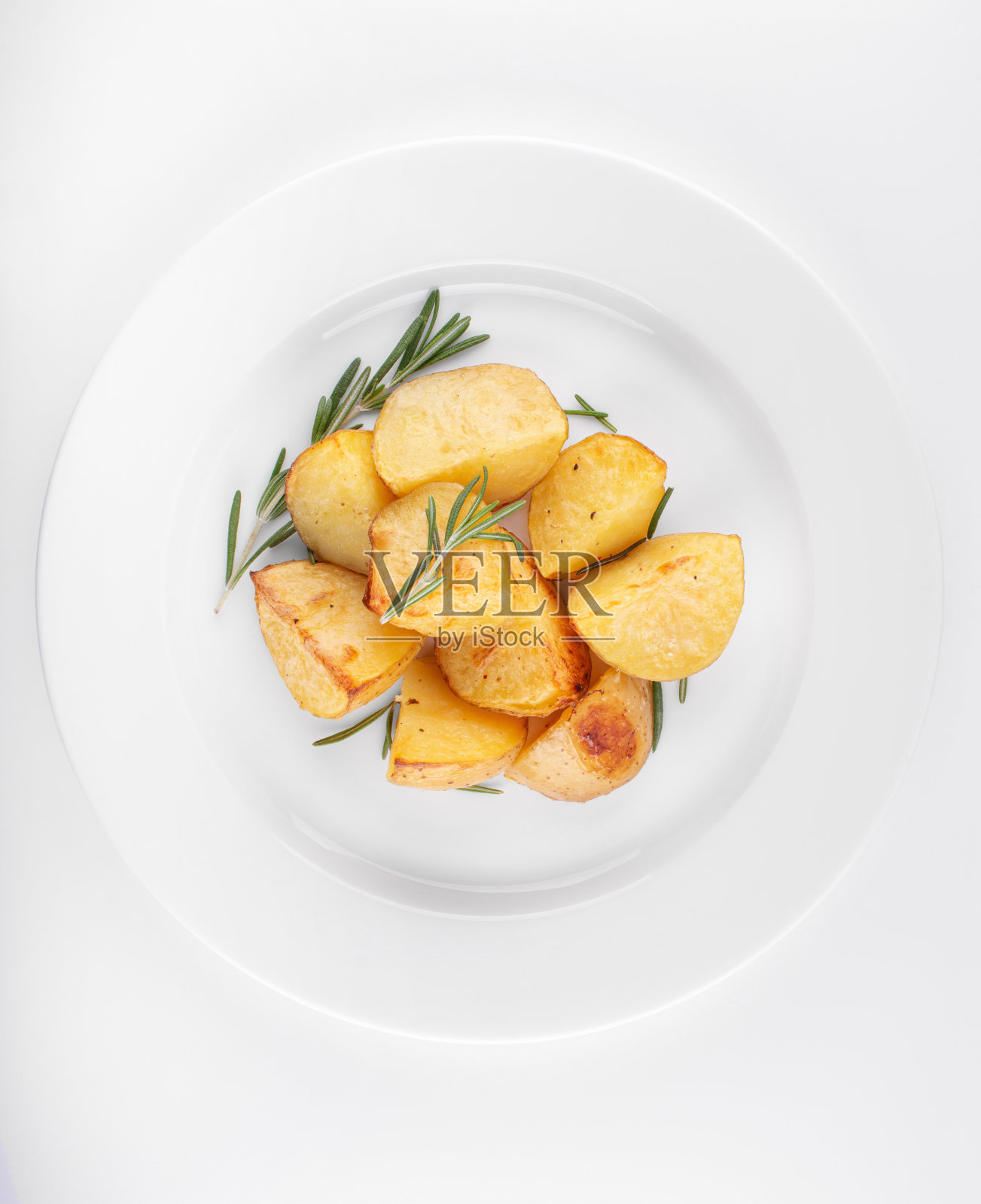 在白色木盘上放上迷迭香烤土豆照片摄影图片