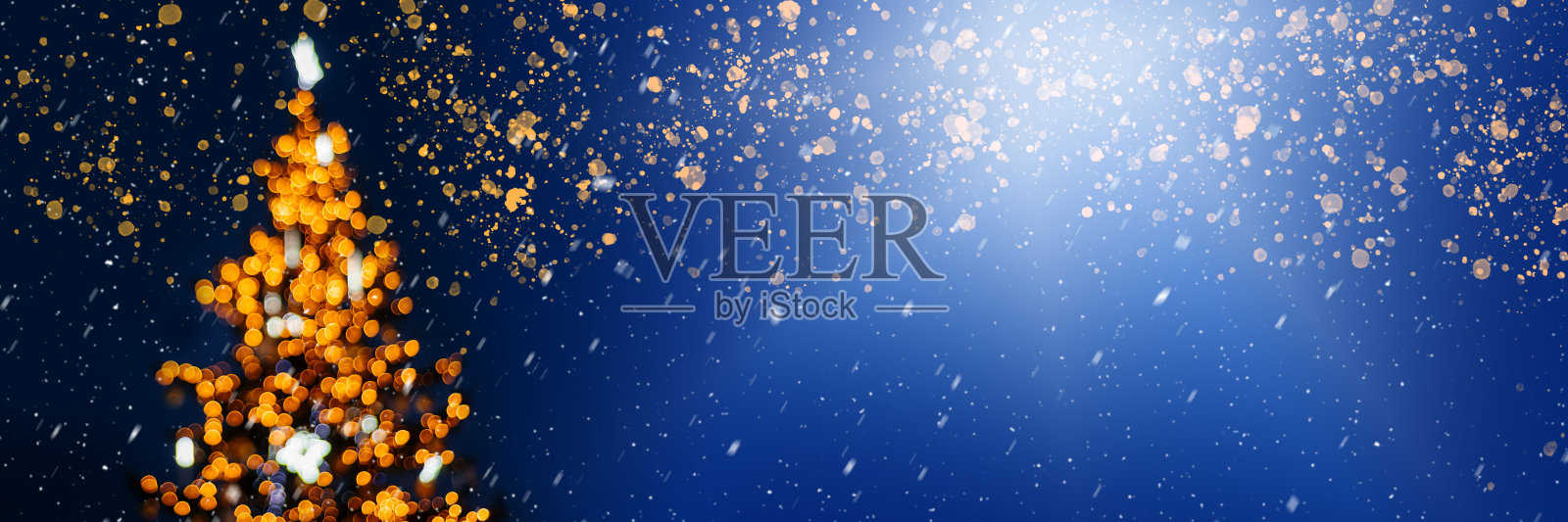离焦圣诞树与灯在深蓝色的背景，横幅大小照片摄影图片