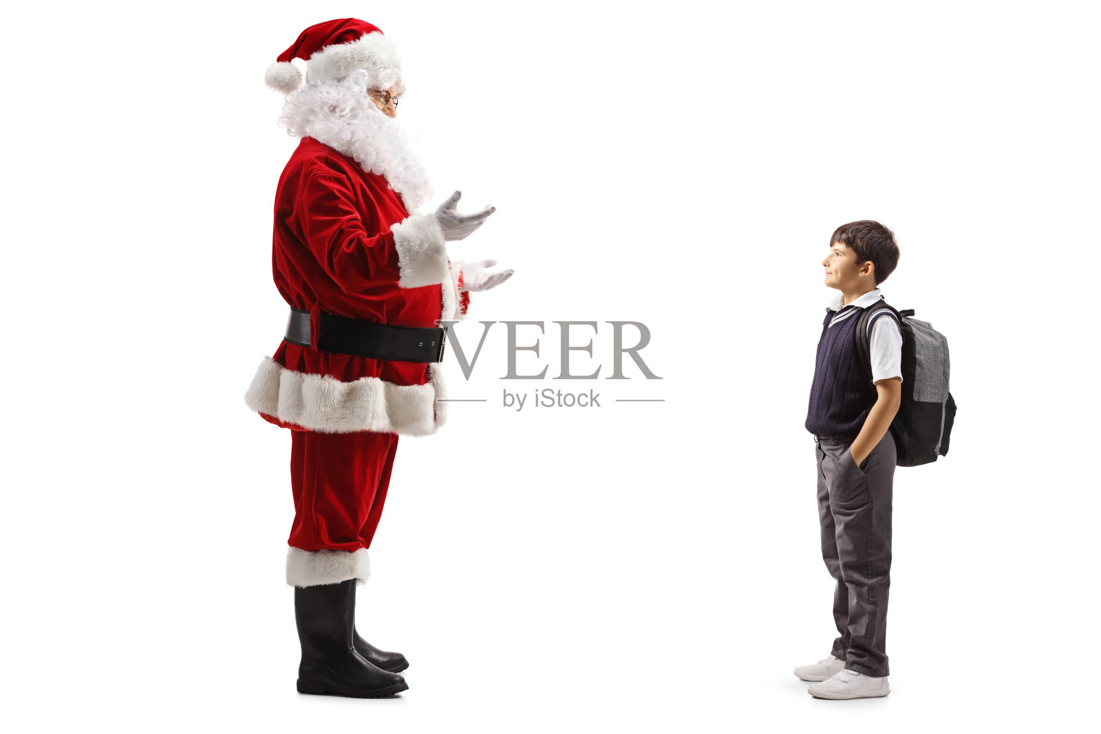 圣诞老人在和一个背着背包，穿着校服的男孩谈话照片摄影图片