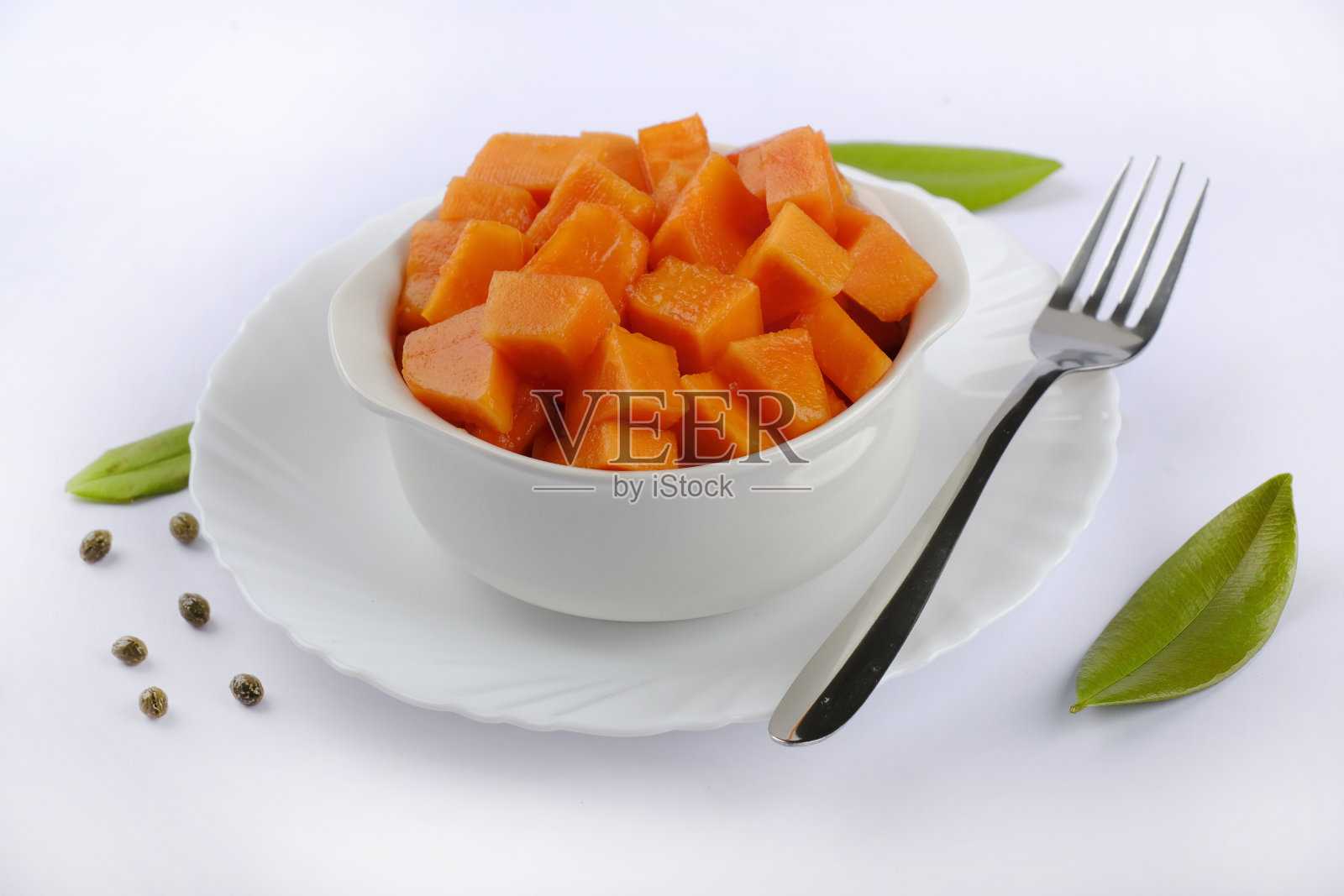 鲜木瓜柳橙放在白碟上，木瓜切片。空间的文本照片摄影图片