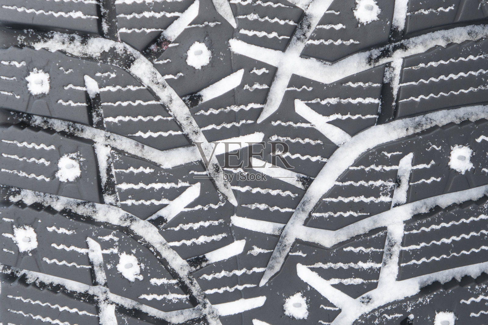 冬天镶满轮胎的背景。冬季汽车轮胎纹理背景与雪。轮胎堆栈的背景。轮胎表面保护。广场强大的峰值。黑色钉状冬季轮胎轮廓。照片摄影图片