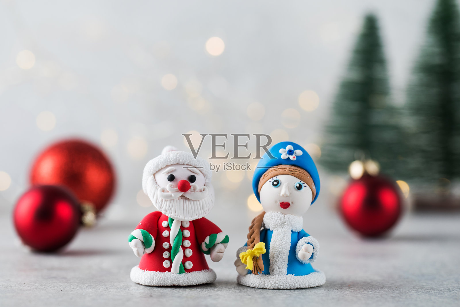 圣诞老人和白雪公主的小雕像映衬着圣诞球和爆竹。新年卡照片摄影图片