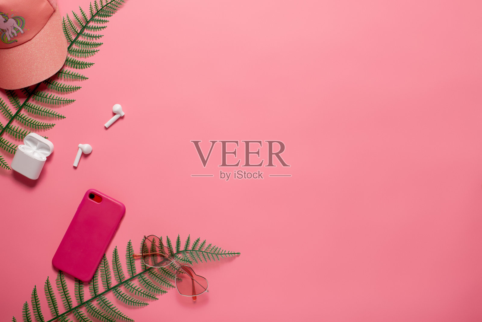 平铺与电话配件和棒球帽。电话，棒球帽和电话配件与复制空间在粉红色孤立的背景平铺照片摄影图片