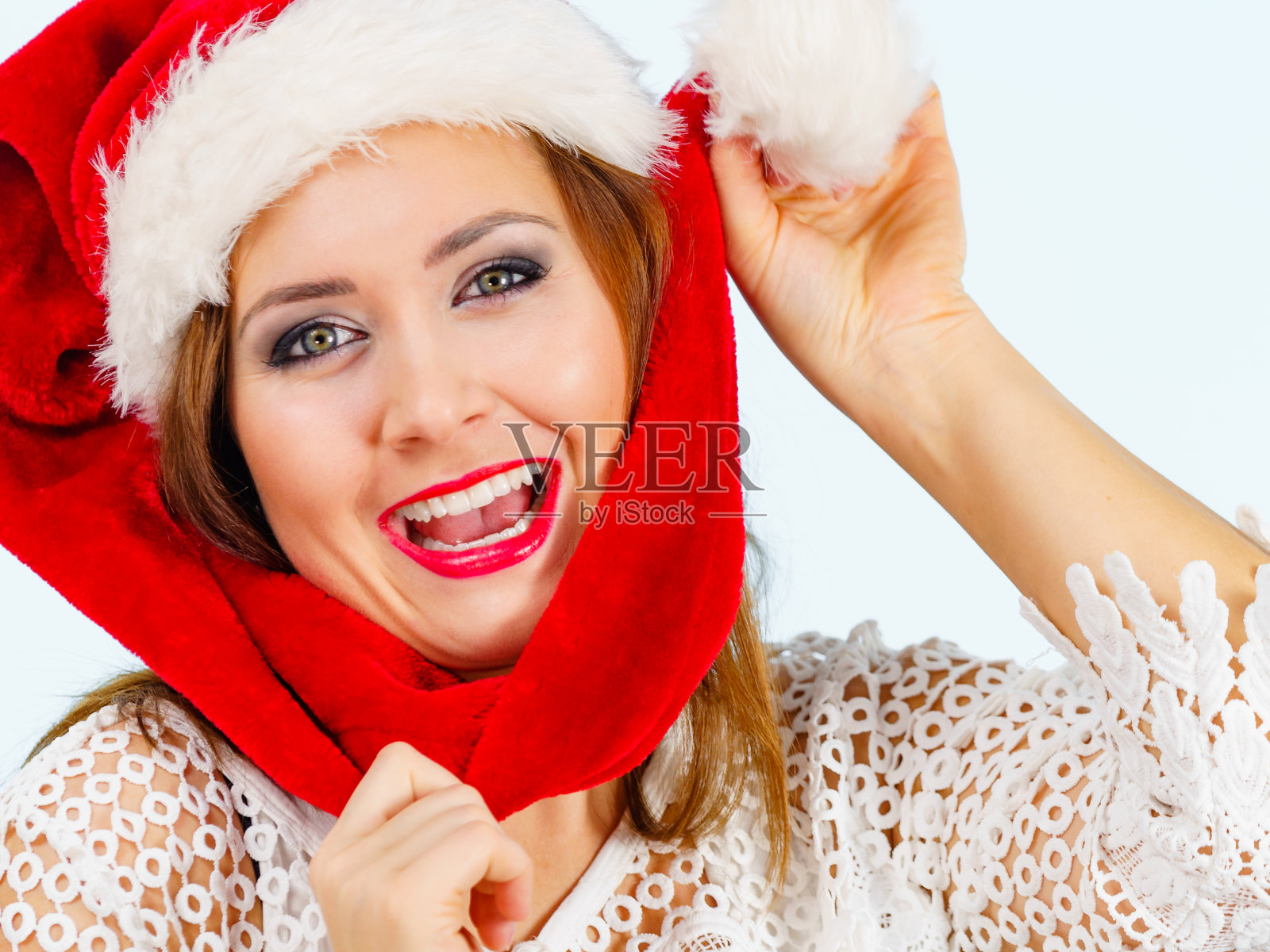 快乐的女人在圣诞老人的帽子照片摄影图片