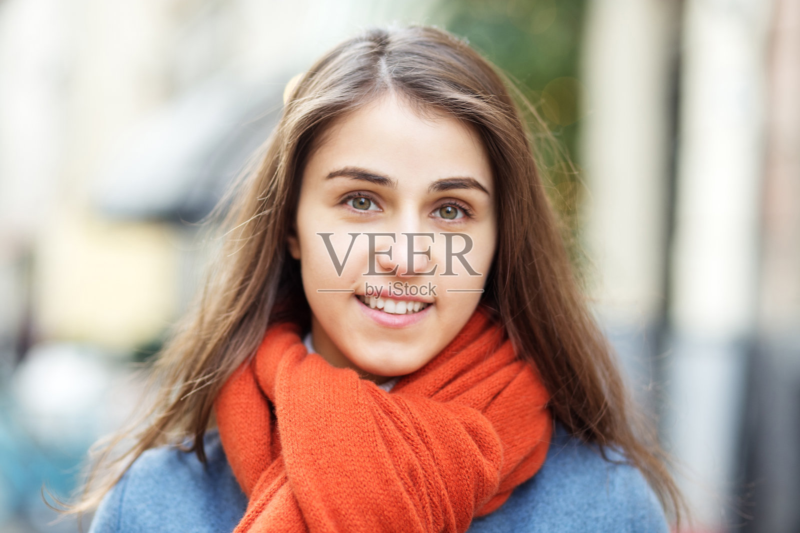 一个戴着帽子和围巾的女孩的肖像，走在圣诞之城，脸上挂着微笑，凉爽的天气，迷人的样子照片摄影图片